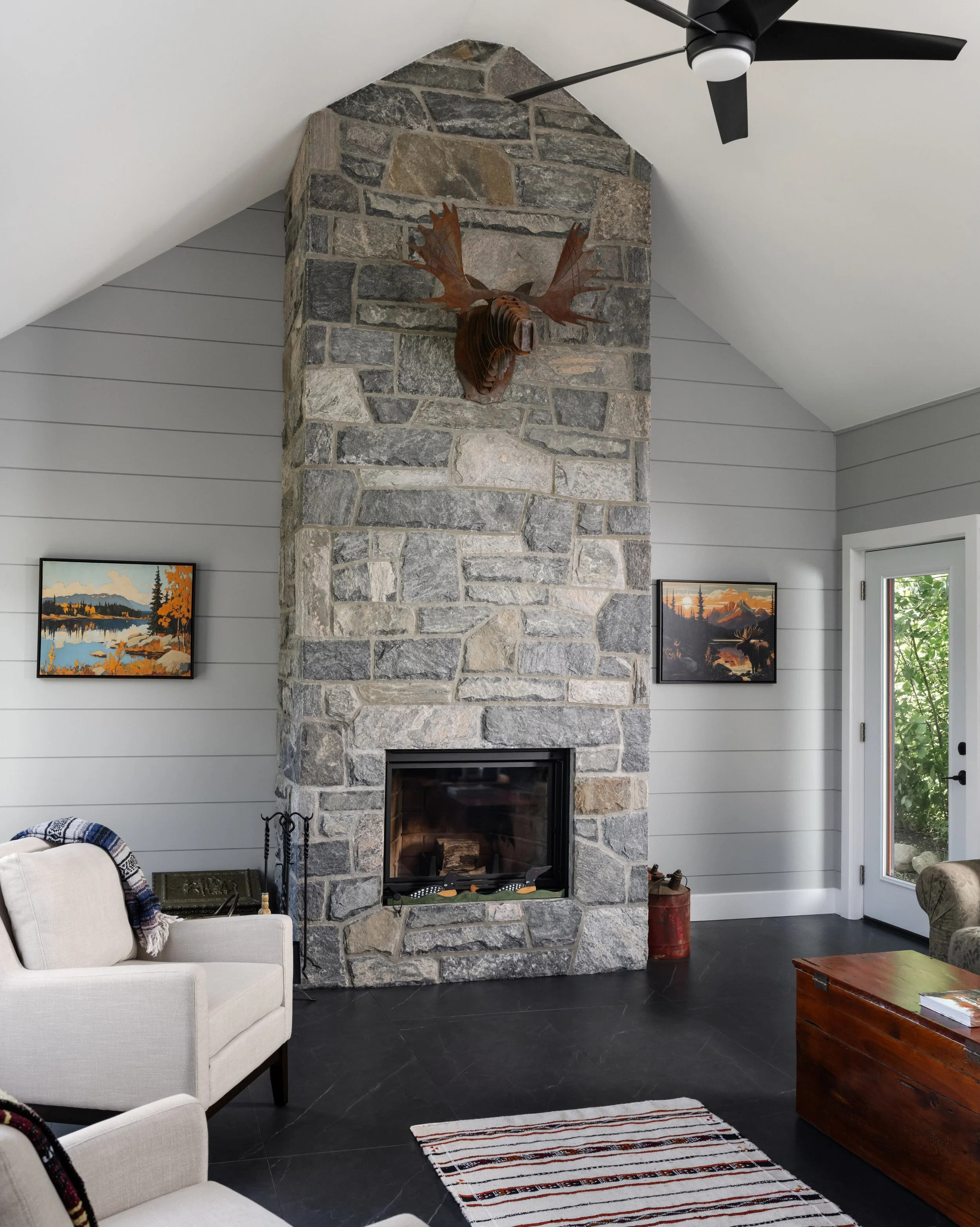 A classic Muskoka living room, defined by locally sourced stone, board and batten walls, and clean vaulted ceiling details.⁠
⁠
⁠Contractor: @bredinbrothers⁠
Architect: @designbybobbi⁠
Building Materials, Window &amp; Door Supply: @rolstonhomebuilding