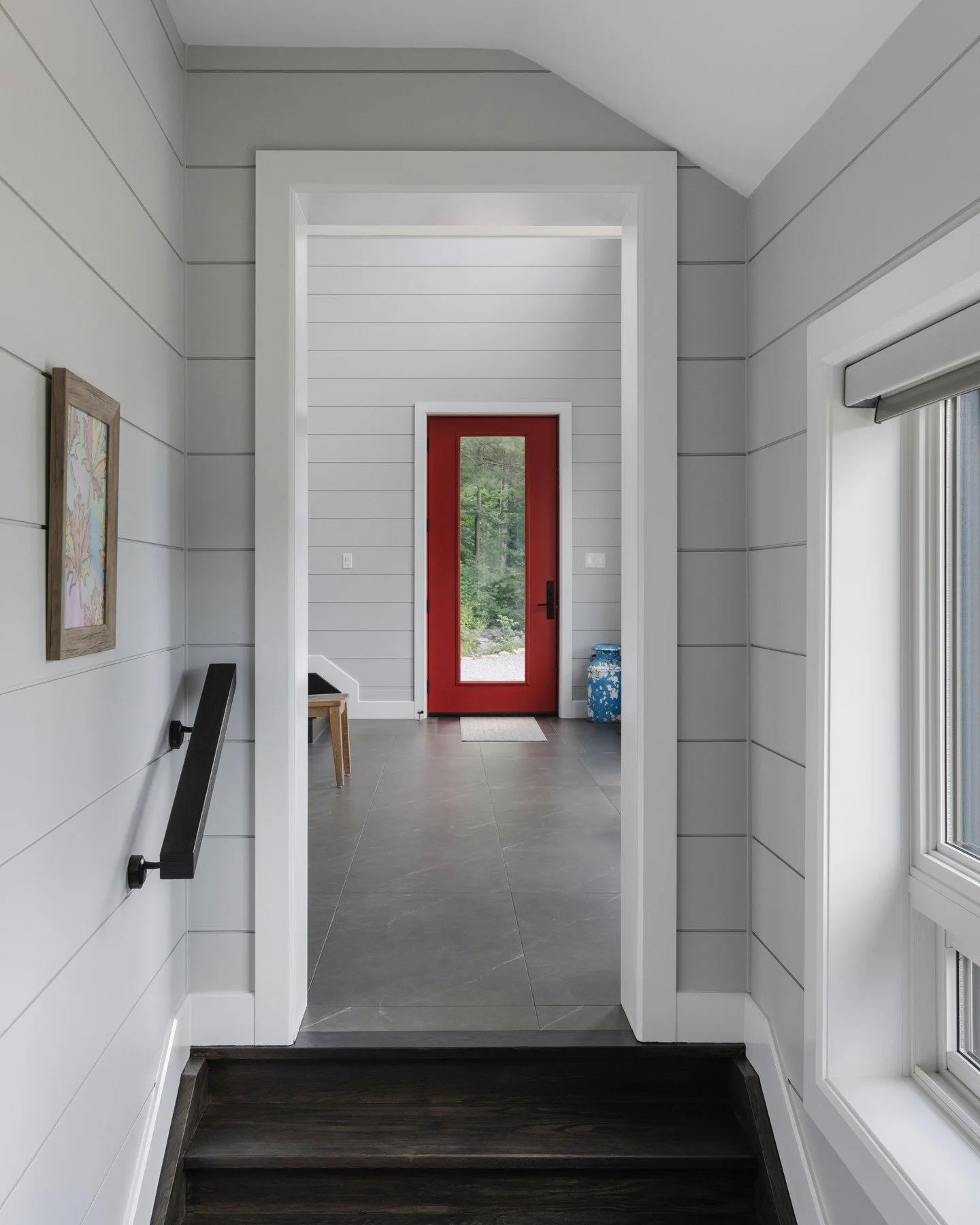 A look inside the front entrance at Sunset Bay Cottage.⁠
⁠
Maintaining continuity between the original cottage and the new additions was a priority throughout construction. The horizontal shiplap carries through the entrance and into the adjoining sp