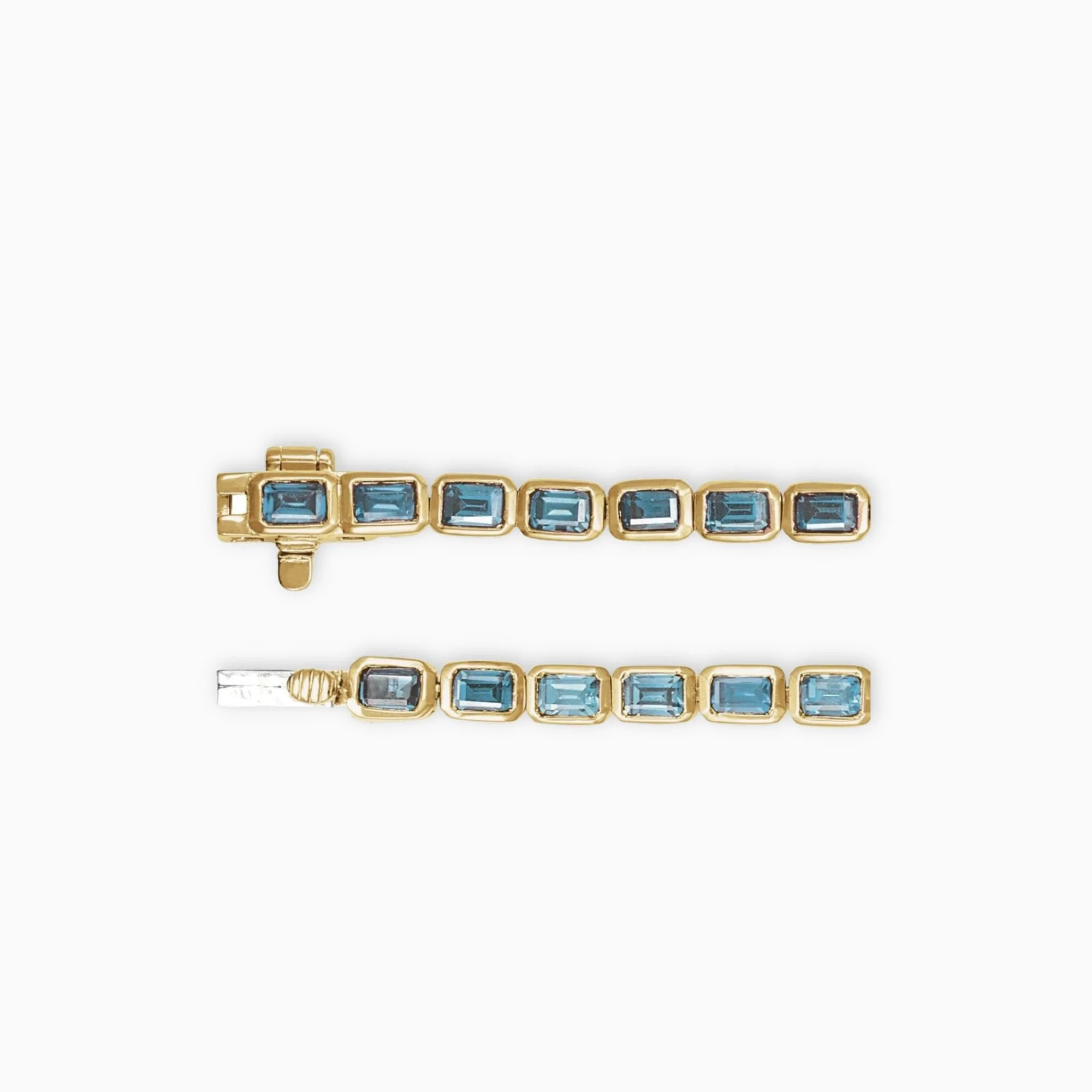 Close up of sky blue topaz tennis bracelet showing emerald cut gemstones in bezel settings