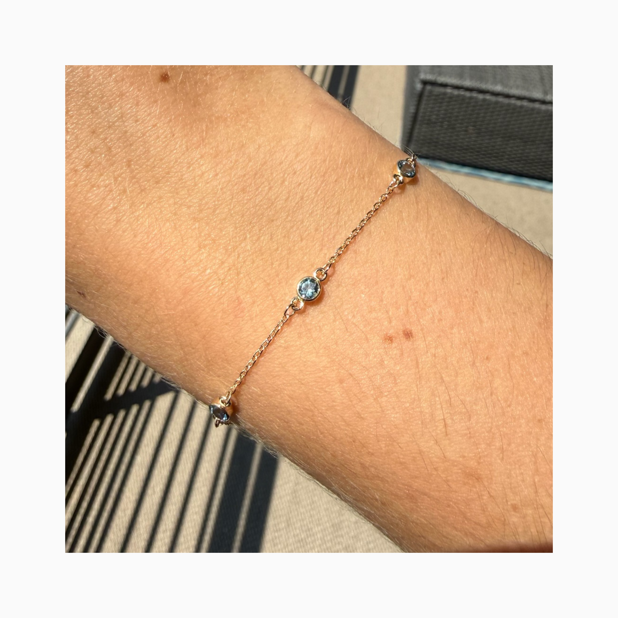14K yellow gold bracelet with three bezel-set natural aquamarine on wrist