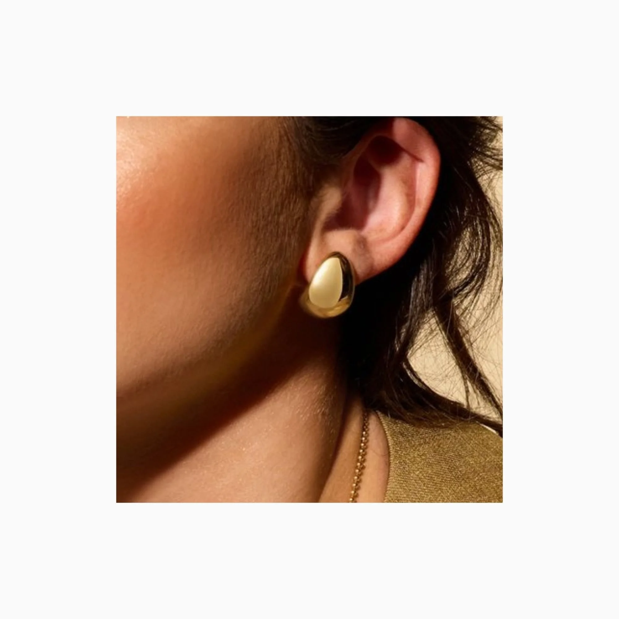 culpted teardrop earrings in polished 14K yellow gold shown worn on ear
