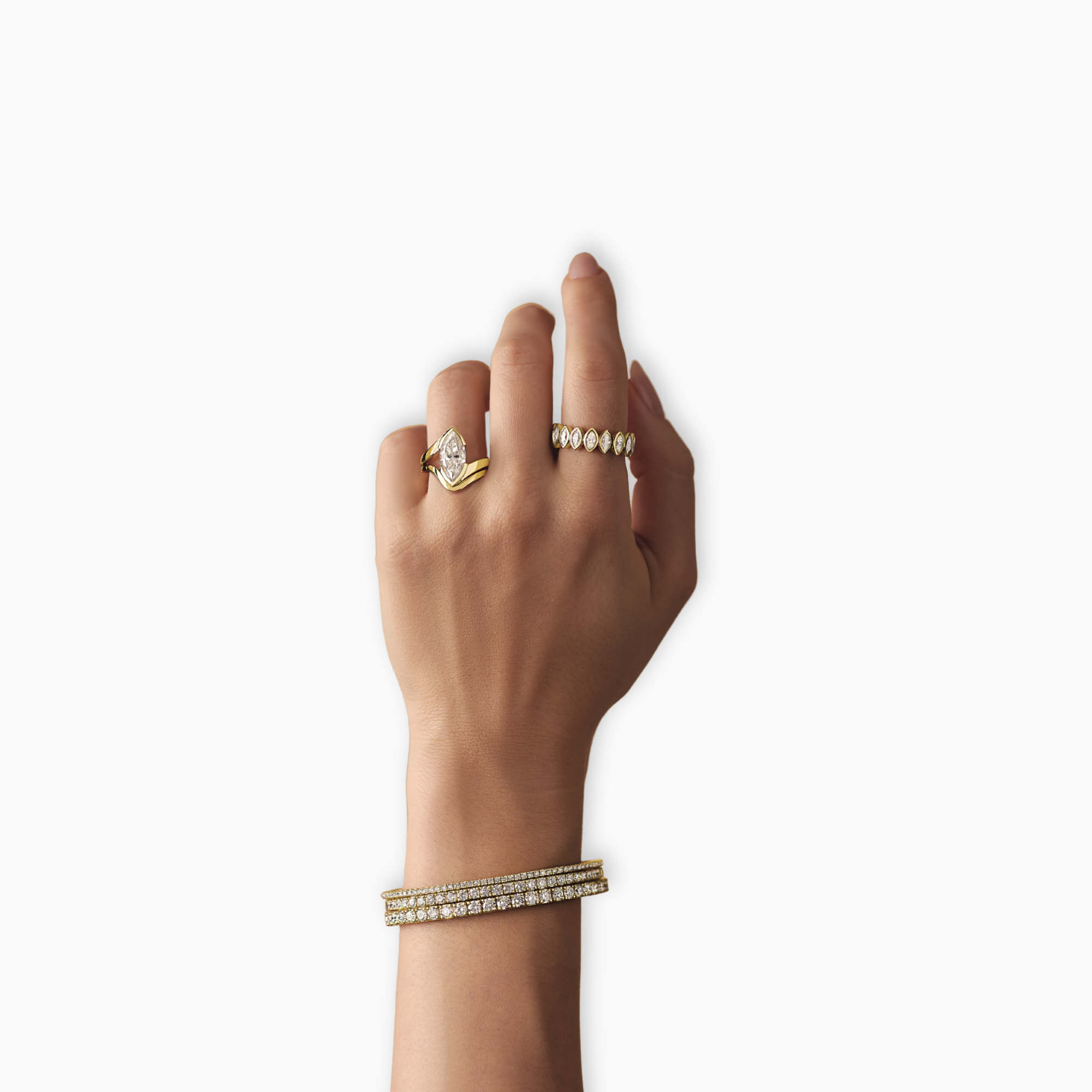 Diadem marquise eternity band in 14K yellow gold with natural diamonds on hand of woman. Marquise engagement ring on ring finger and stack diamond tennis bracelets on wrist