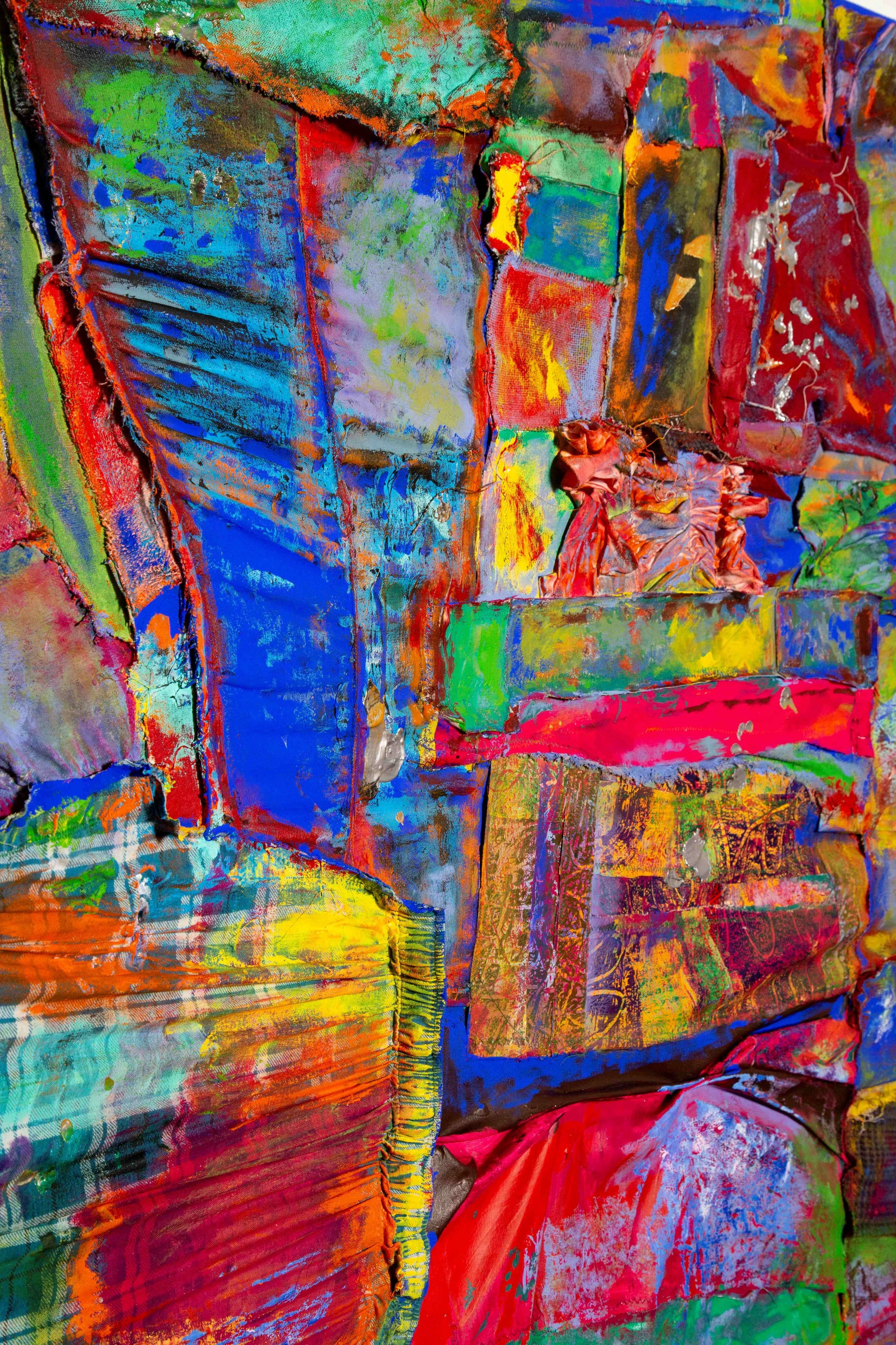 Abstract colorful artwork with overlapping textured patches of various colors including blue, red, green, yellow, and orange.