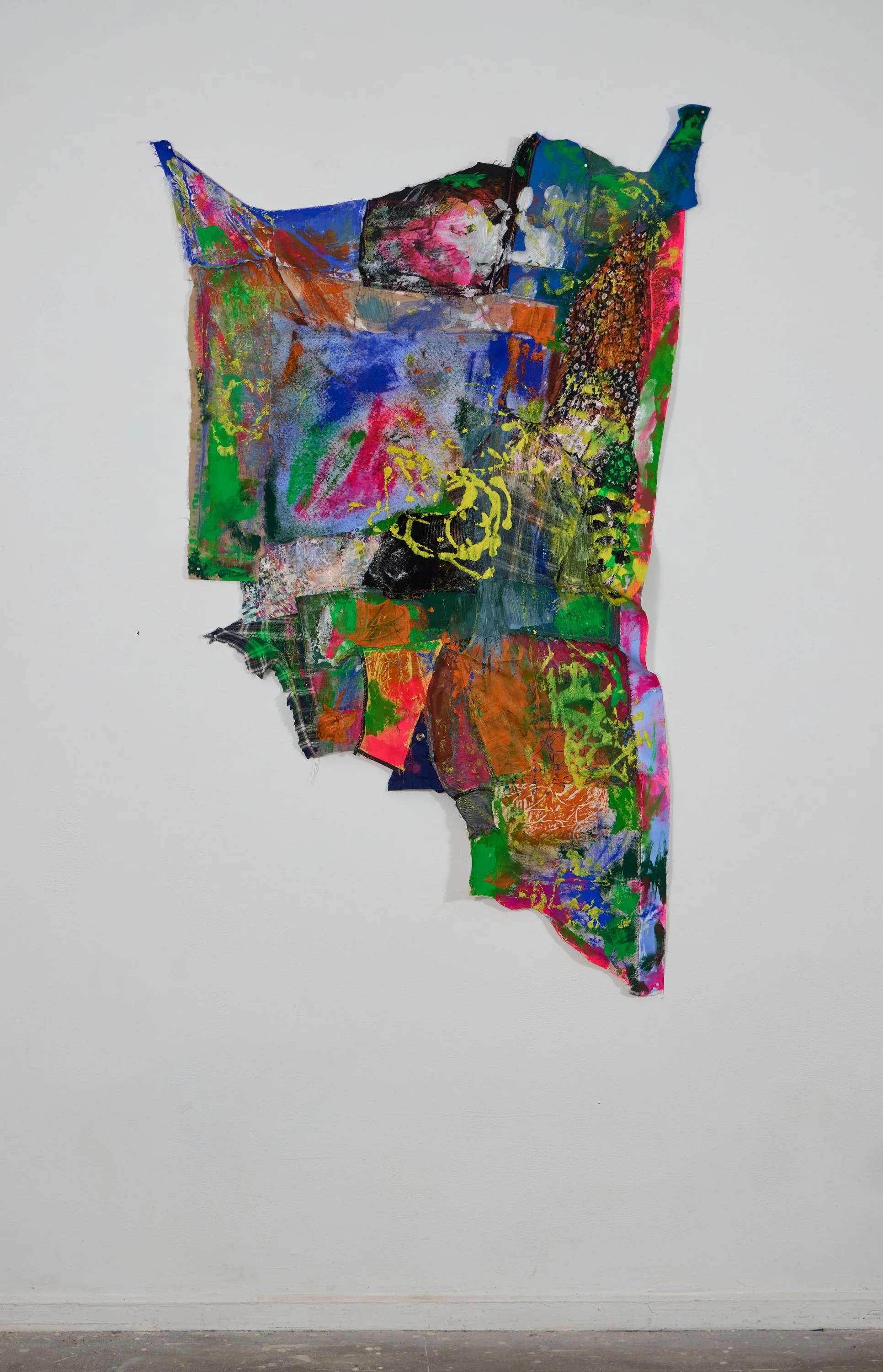 An abstract mixed-media artwork on a white gallery wall featuring bright, vivid colors and layered textures.