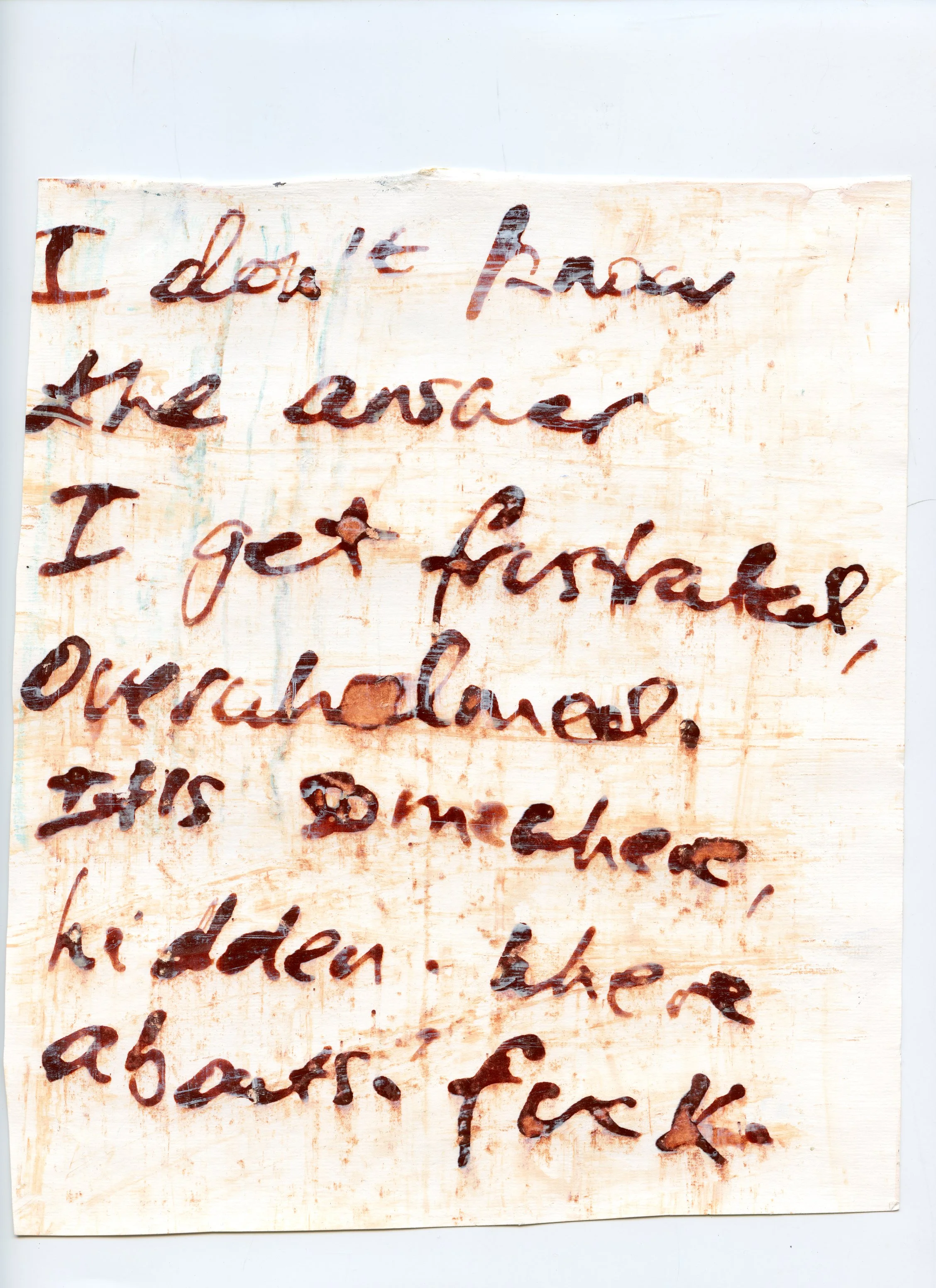 A handwritten note on a piece of paper in reddish brown ink