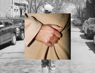 Close-up of a person in a beige coat pointing with their index finger, with a street scene and parked cars in black and white in the background.