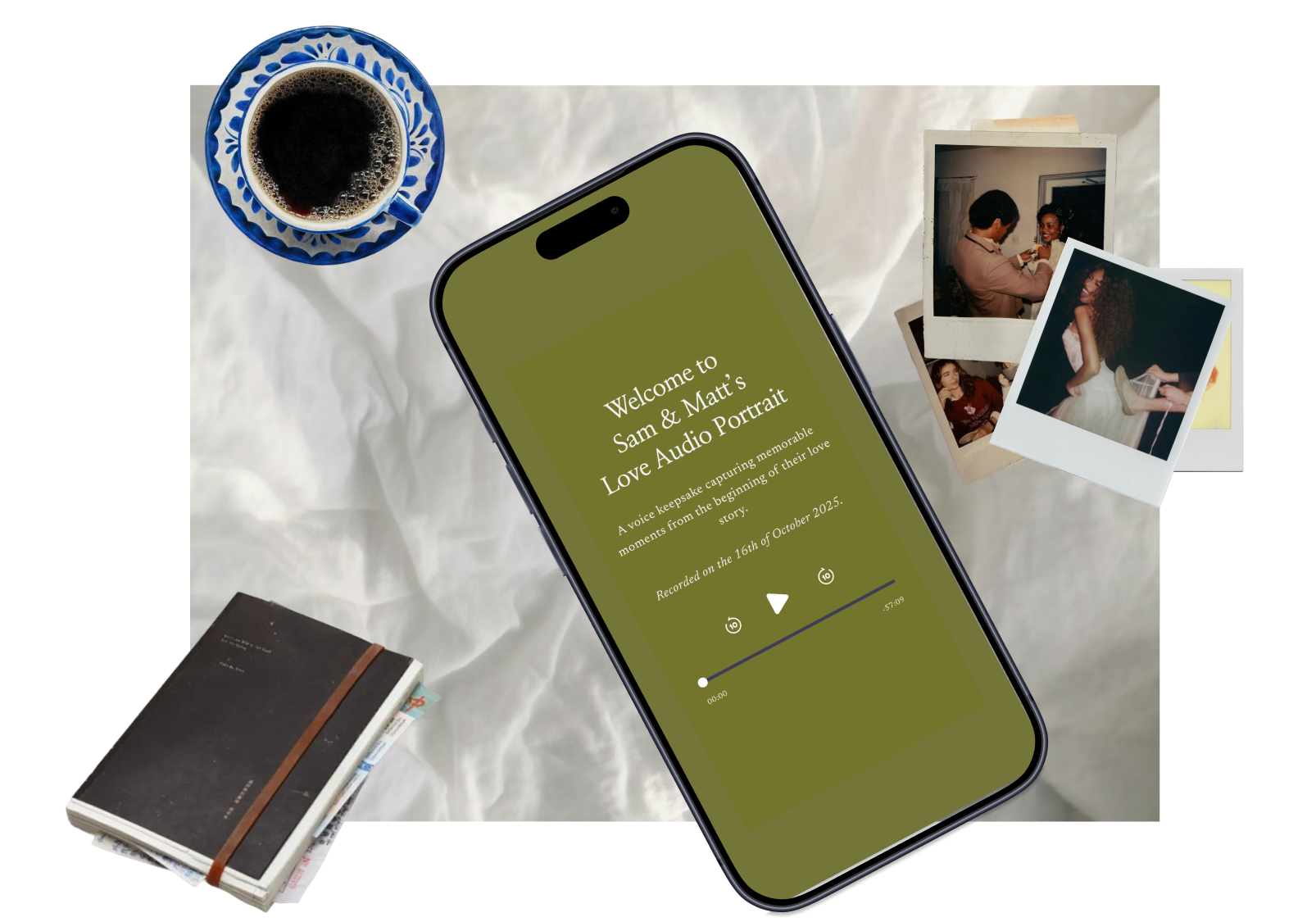 Smartphone displaying a welcome message for Sam and Matt's Love Audio Portrait, with a cup of coffee, two Polaroid photos, and a closed journal on a crumpled white paper background.