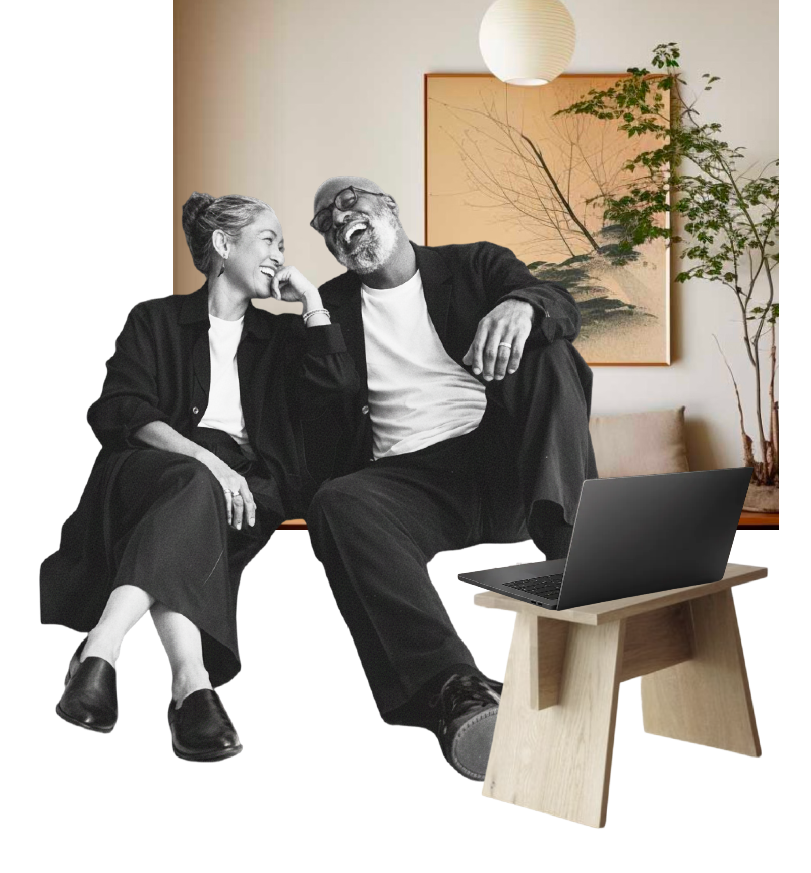 A black and white photo of a woman and a man sitting together, laughing and sharing a moment of joy. They are in a contemporary room with a Japanese-style landscape painting and a potted plant in the background. A laptop is placed on a small wooden table in front of them.