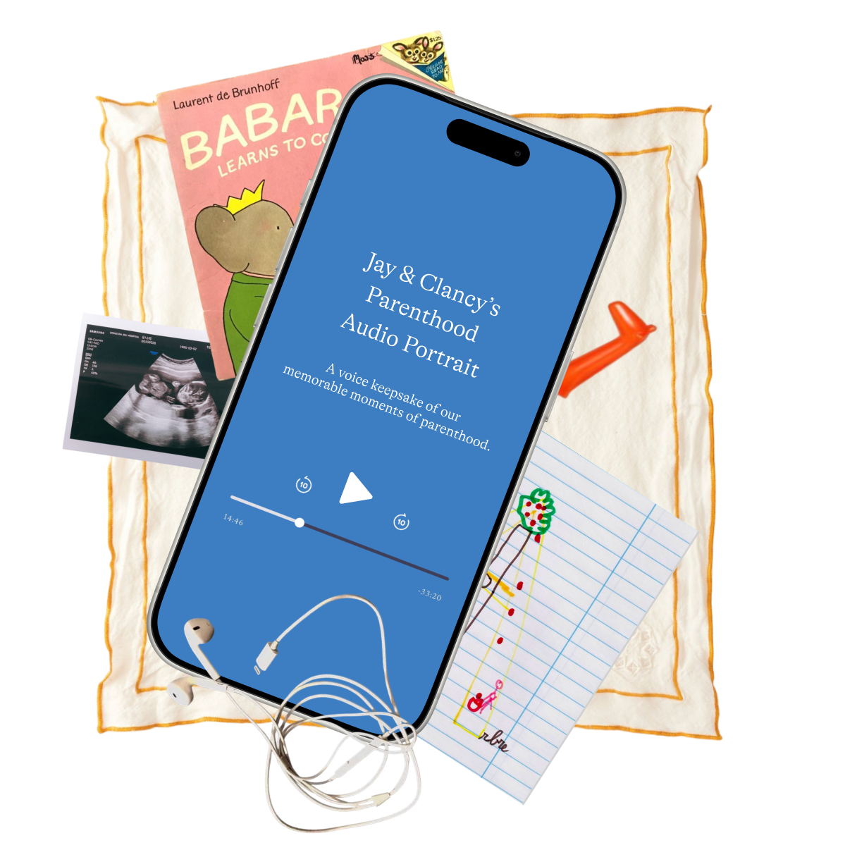A collection of items for a gender reveal, including a smartphone displaying a podcast titled 'Jay & Clancy's Parenthood Audio Portrait', a pink book titled 'BABA Learns to Co', a sonogram photo, a drawing of a tree on lined paper, and a cloth with a red watering can on it.