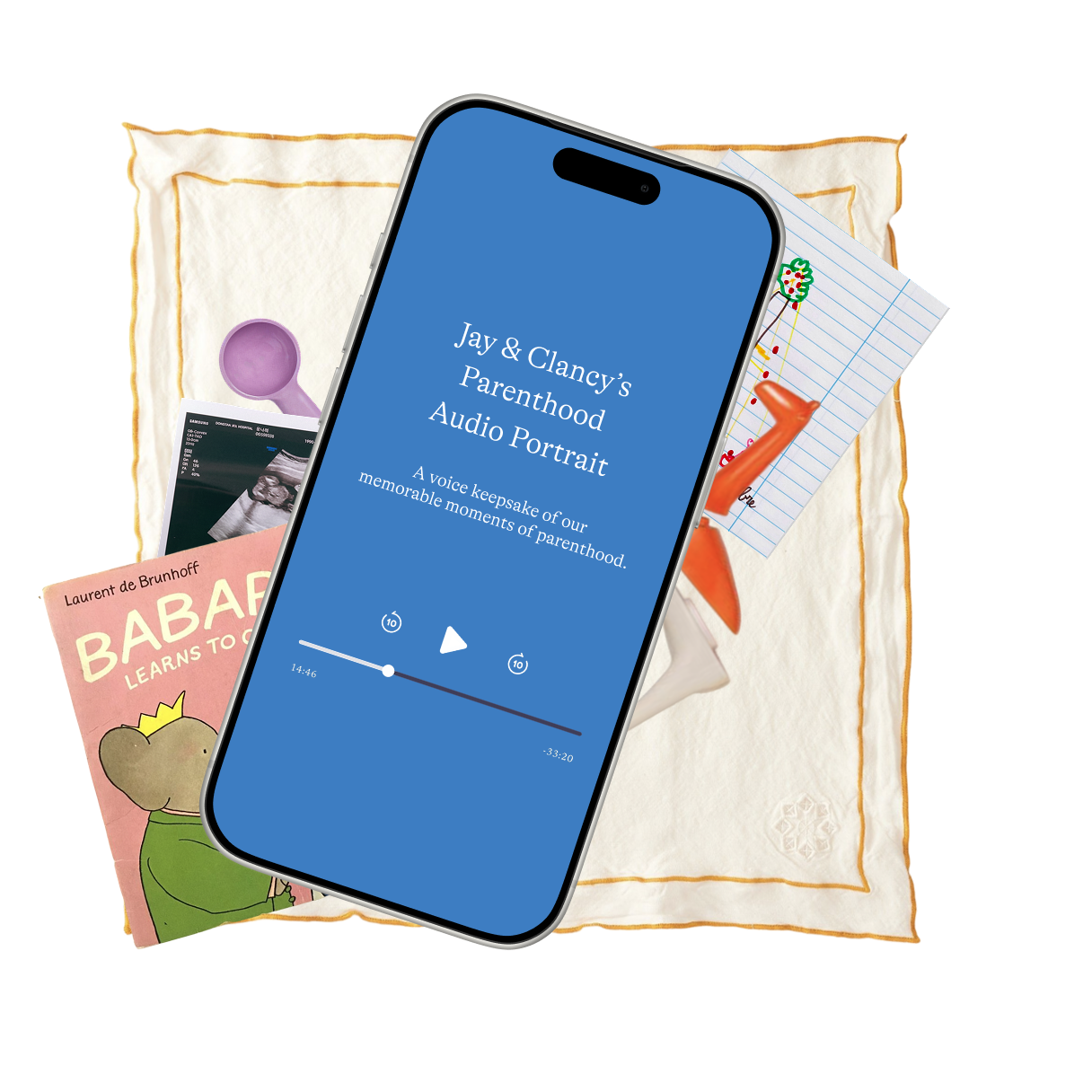 Smartphone with a podcast titled 'Jay & Clancy's Parenthood Audio Portrait,' resting on a cloth with children's toys, a book about a baby, and a ultrasound photo.
