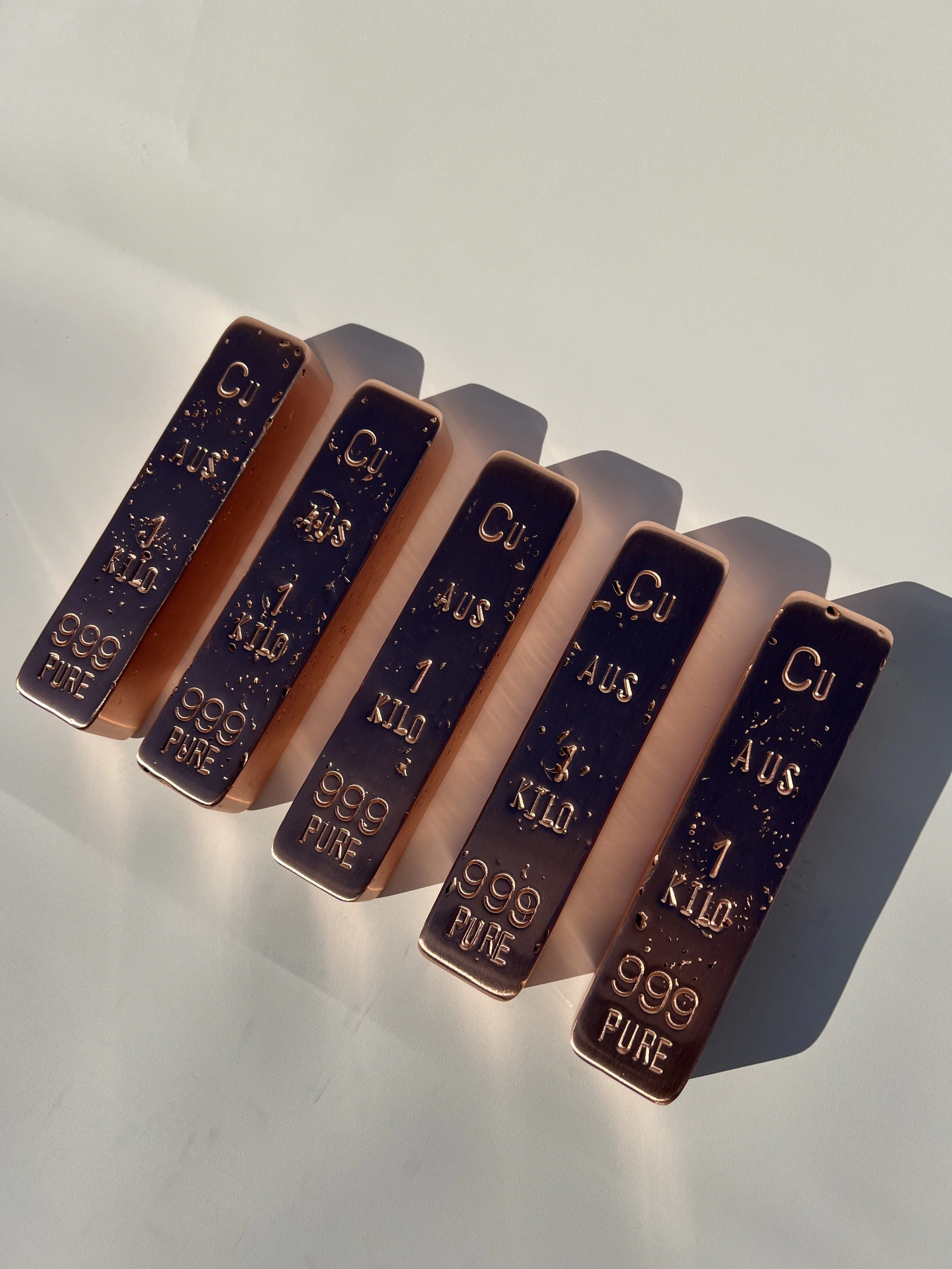 Hand cast 1kg copper bullion bars 999 fine arranged in row