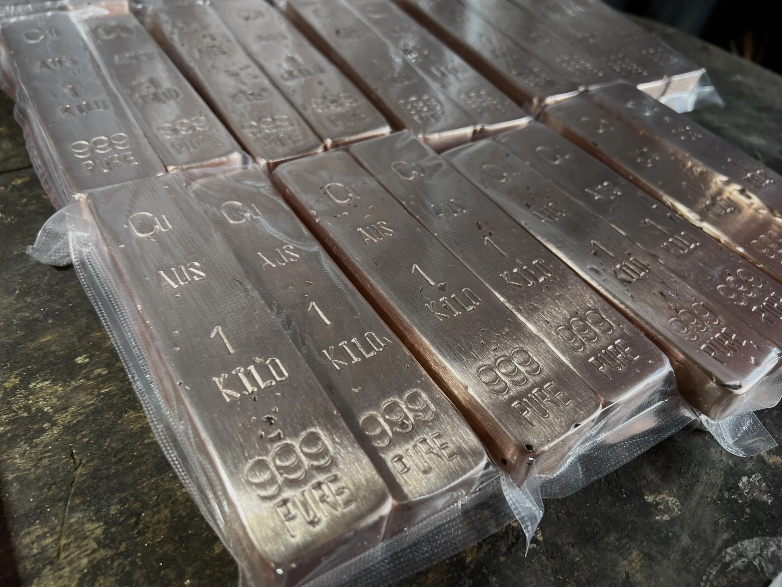 Stacked copper bullion bars with stamped markings 999 fine Australia