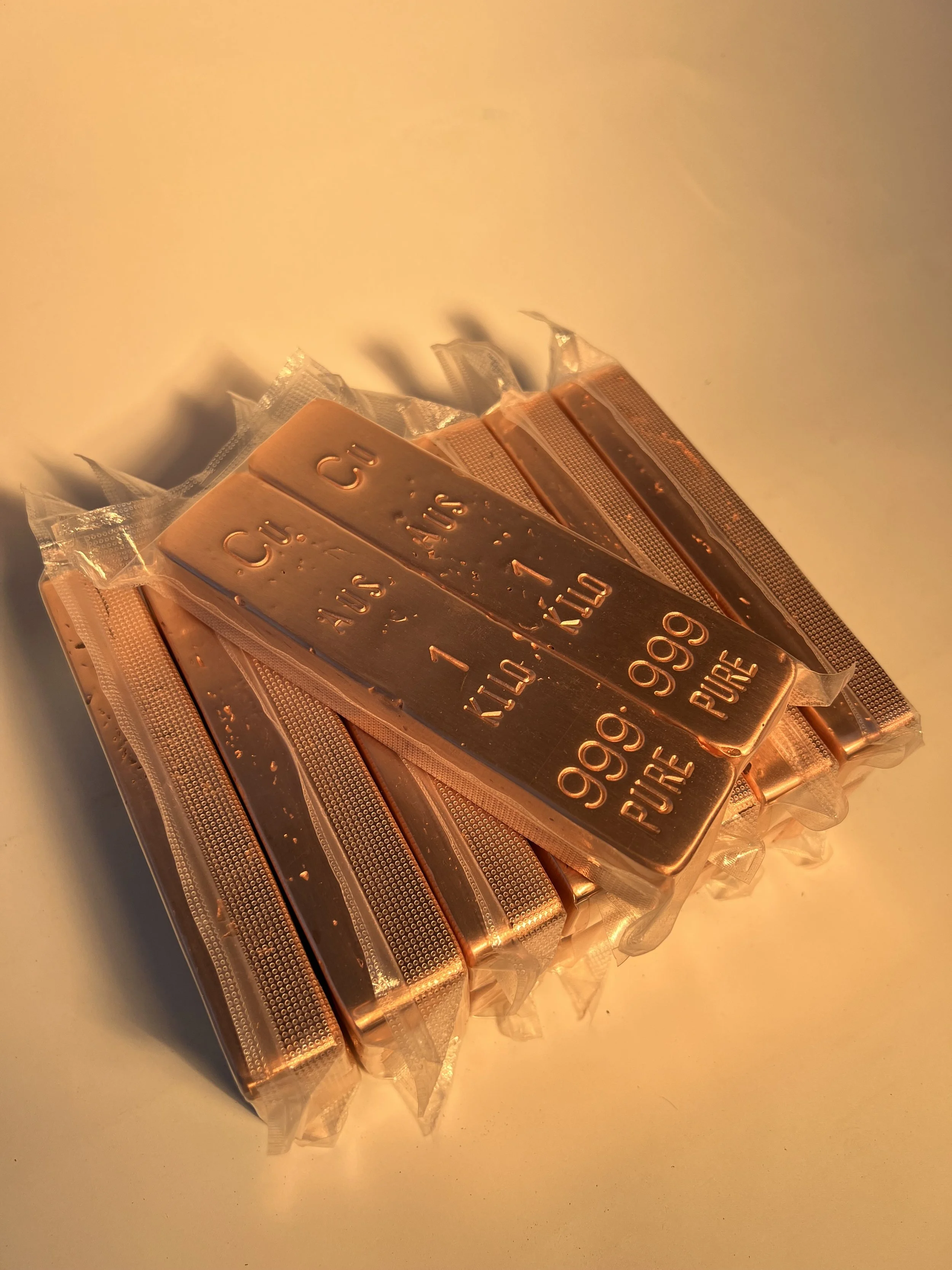 Stacked copper bullion bars close up with engraved markings 999 fine Australia