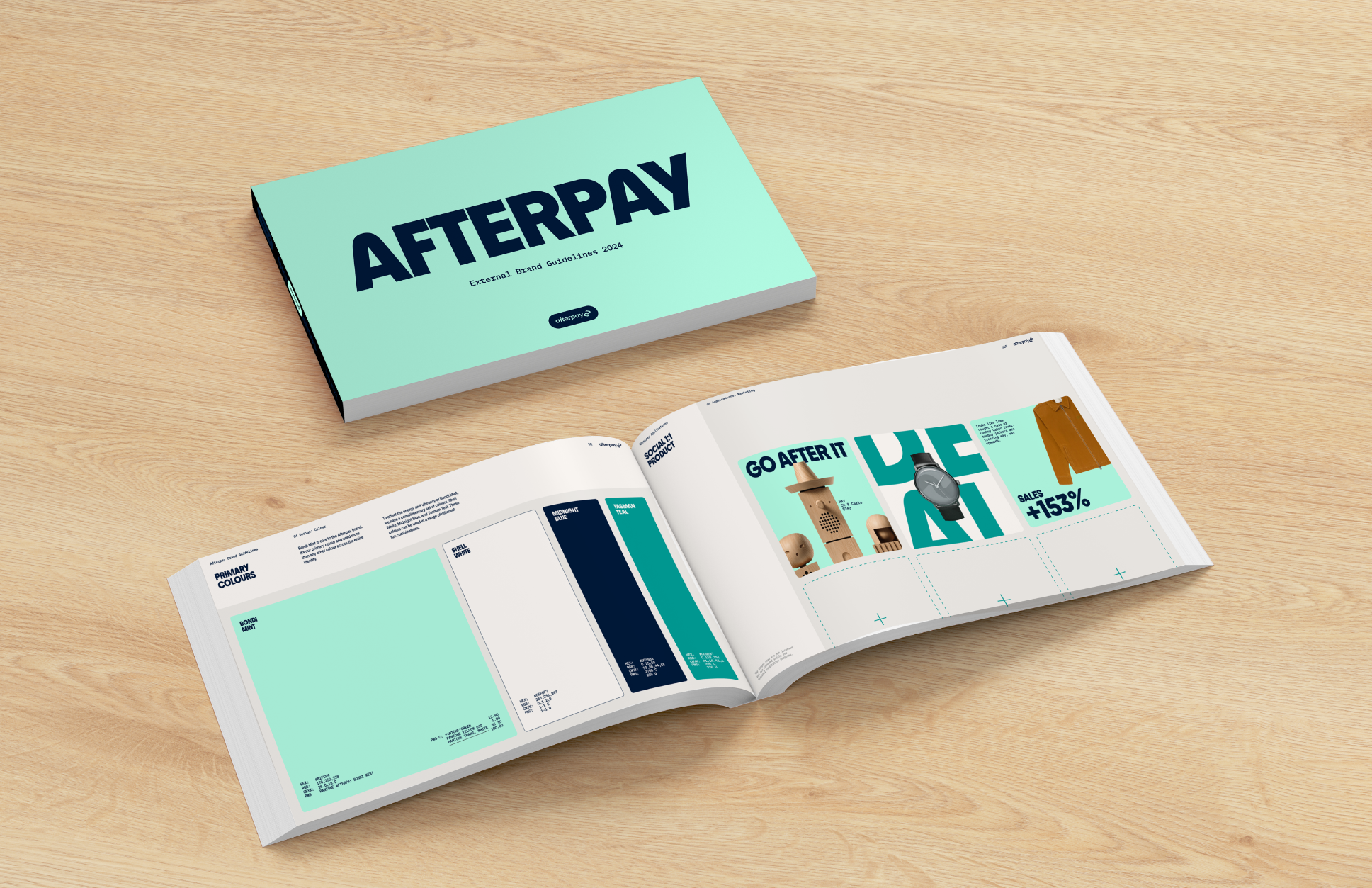 Open brand guidelines booklet titled 'AFTERPAY' on a wooden table, showing pages with brand colors, product images, and promotional content.