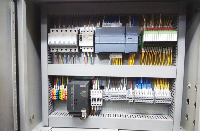 Electrical control panel with various wires, circuit breakers, relays, and terminals.