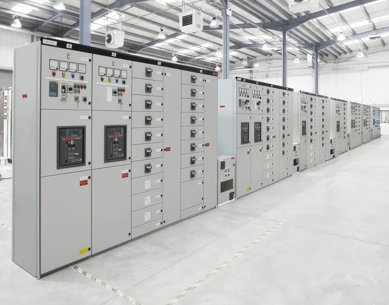 Large electrical control panels inside a spacious industrial facility.