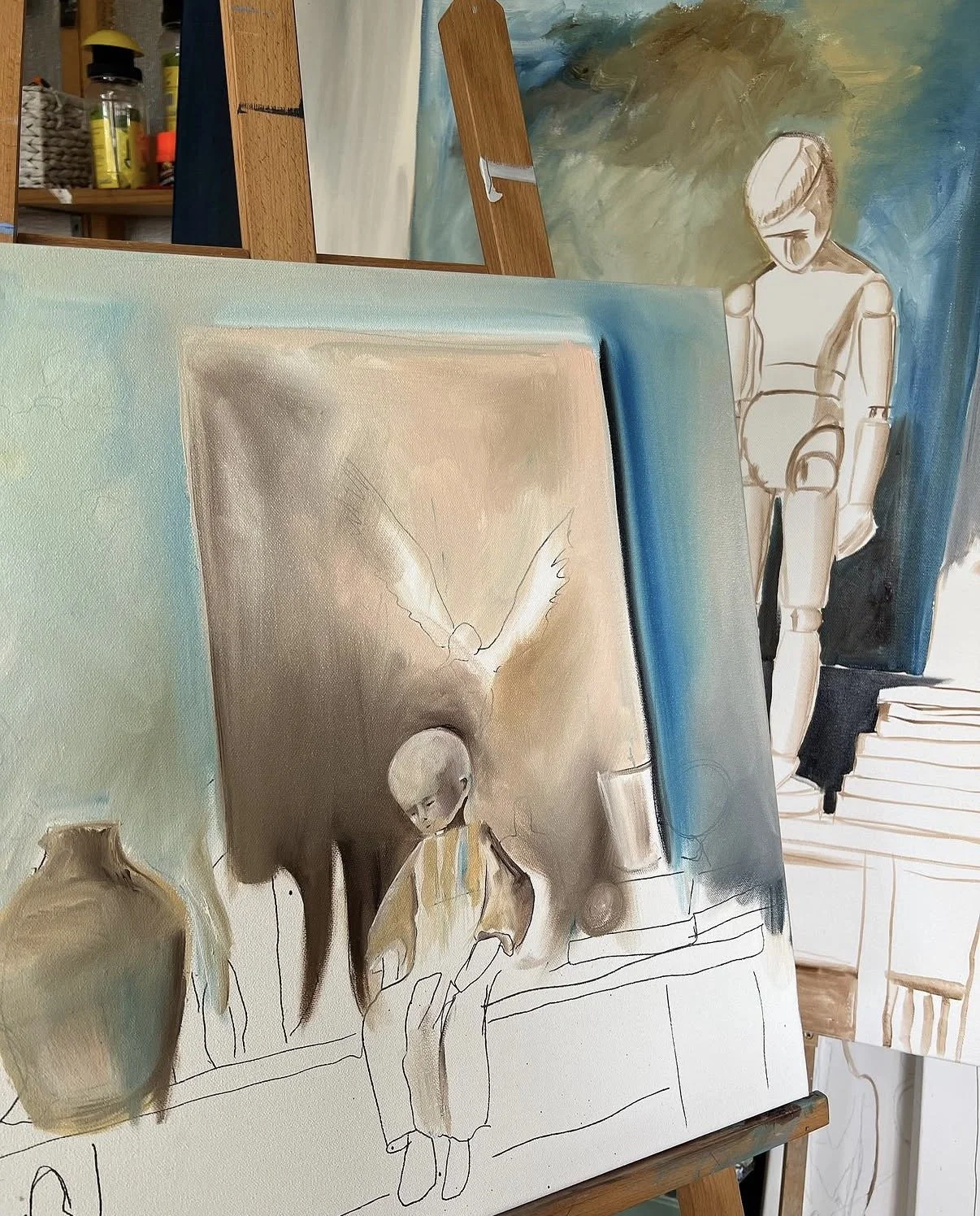 A canvas of an unfinished painting of a young boy sitting on a ledge with a large vase next to him, surrounded by a mix of abstract and realistic elements, with a second, more complete portrait of the boy in the background on another canvas.