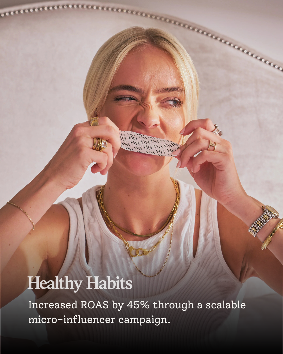 A woman with blonde hair tying her lip with a patterned white and black cloth, wearing jewelry, and a white tank top, with the text 'Healthy Habits' and 'Increased ROAS by 45% through a scalable micro-influencer campaign.'