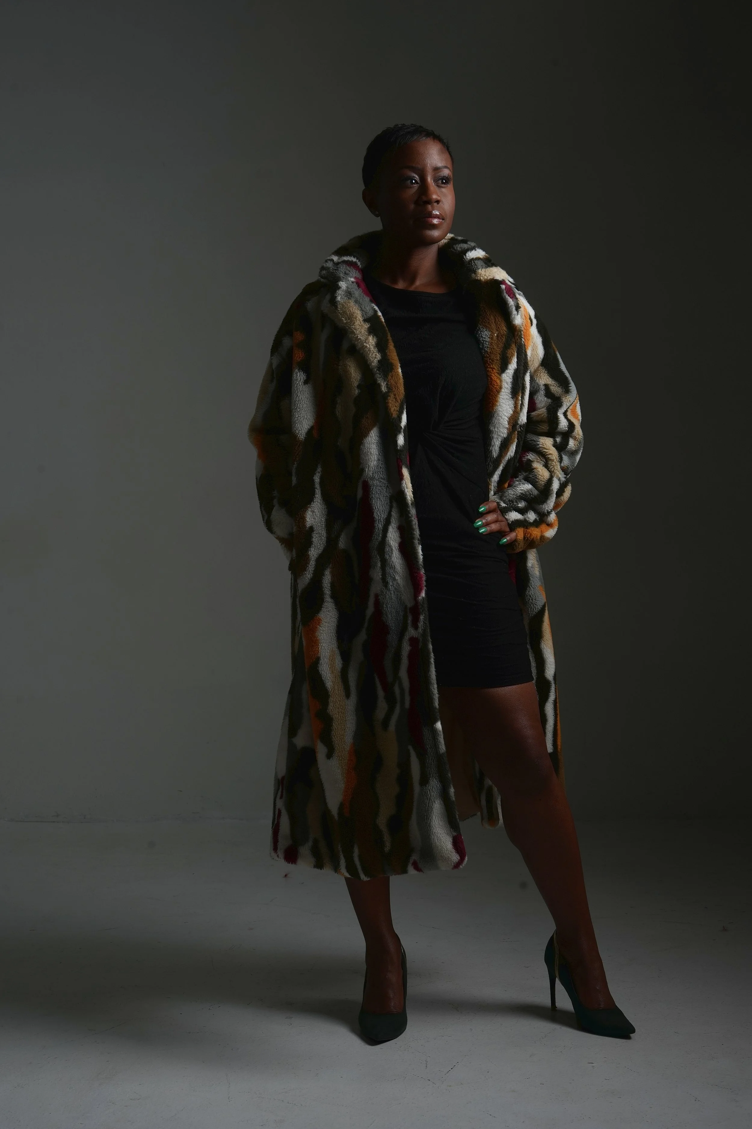 Paleta Henderson, poet and motivational speaker known as Jus’Poetic, standing confidently in a patterned coat