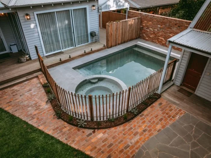 view of pool with fence and paving .jpg