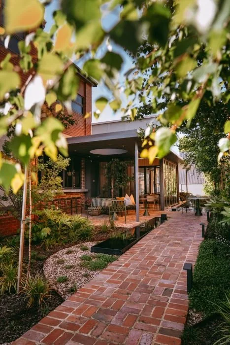 brickwork path through landscaped garden with trees and grasses.jpg