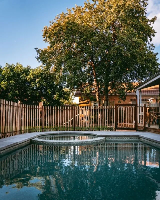 long shot of pool with fence and trees behind it.jpg
