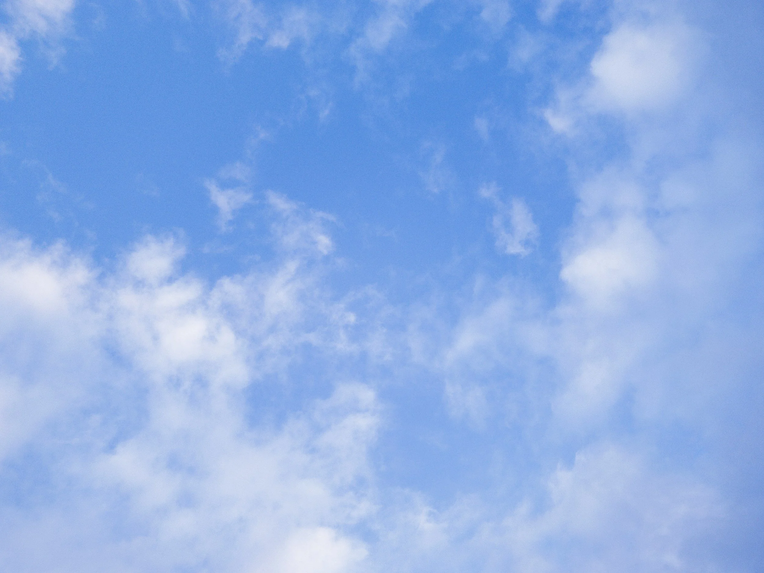 Clear blue sky with some scattered white clouds.