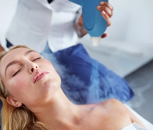 A woman lying down with eyes closed as a medical professional uses a handheld device on her chest.