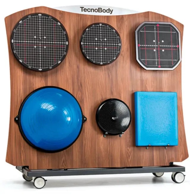 Fitness equipment display board with three reaction balls, balance disc, speaker, and a blue cushion on a wooden stand