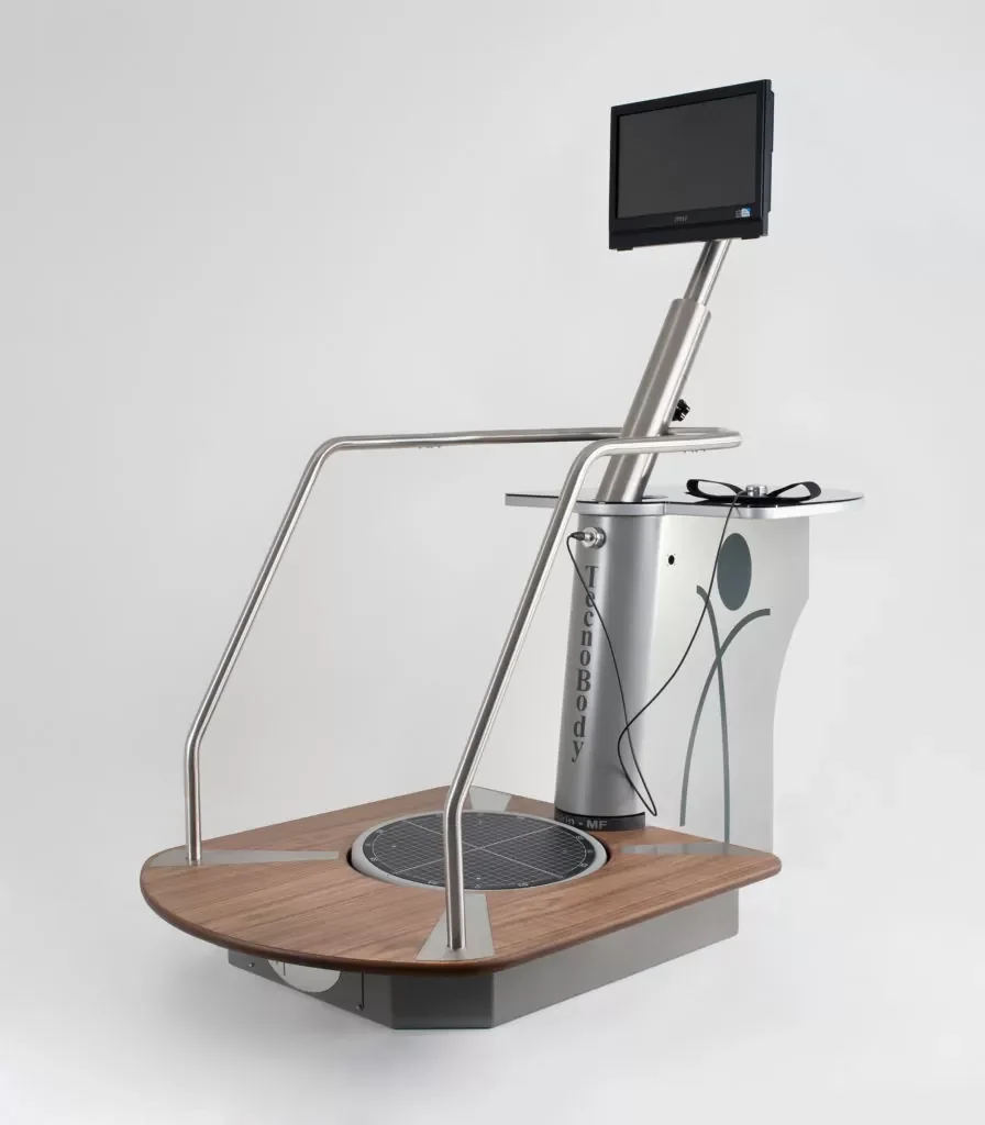 A treadmill with a built-in monitor, safety rails, and a wooden platform base.