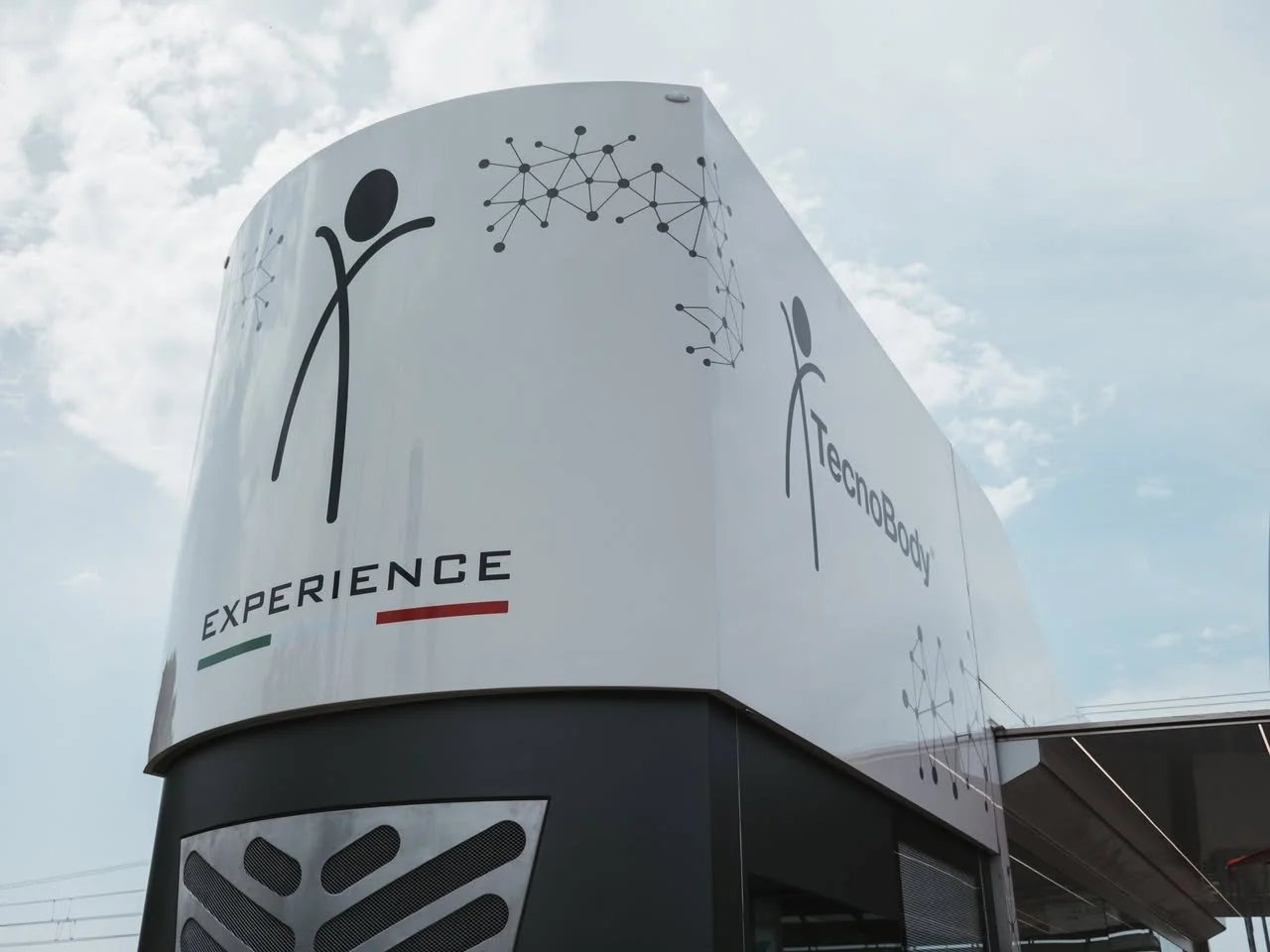 A large white structure with illustrations and text promoting technology experience, featuring a stylized human figure and network graphics.