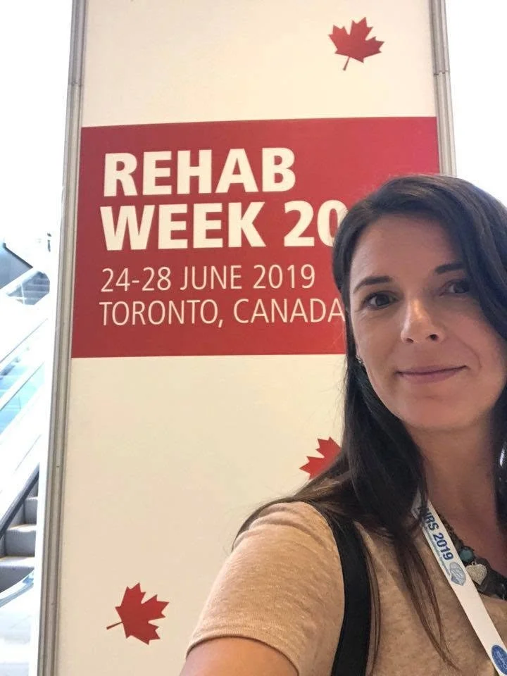 A woman taking a selfie in front of a sign for Rehab Week 2019 in Toronto, Canada, which took place from June 24-28, 2019.