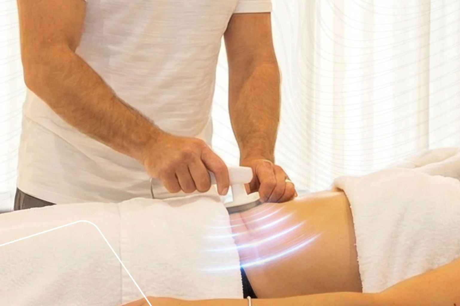 Person using a massage tool on a patient's thigh.