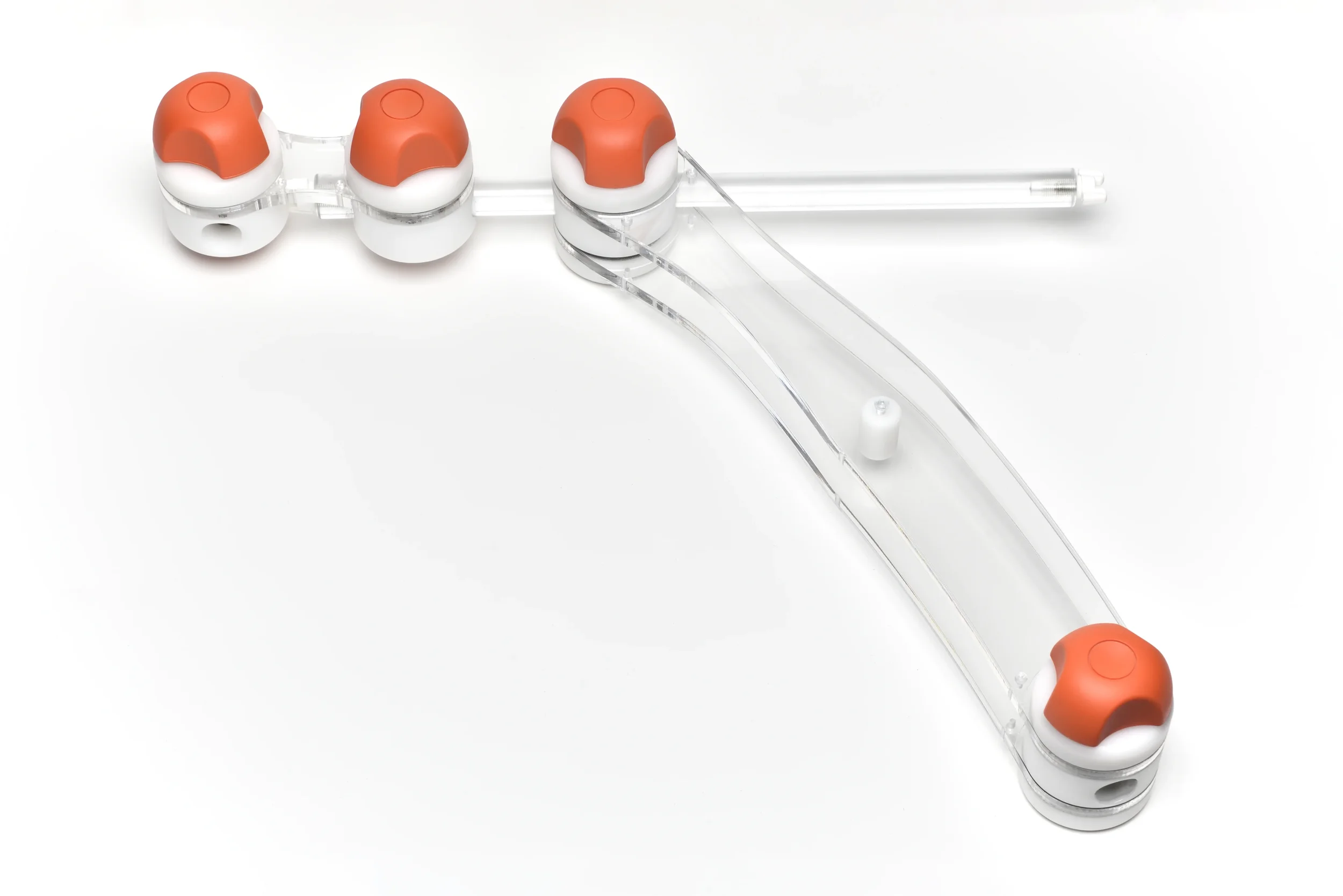 Close-up of an intravenous (IV) drip set with three orange and white plastic adapters connected to clear plastic tubing.
