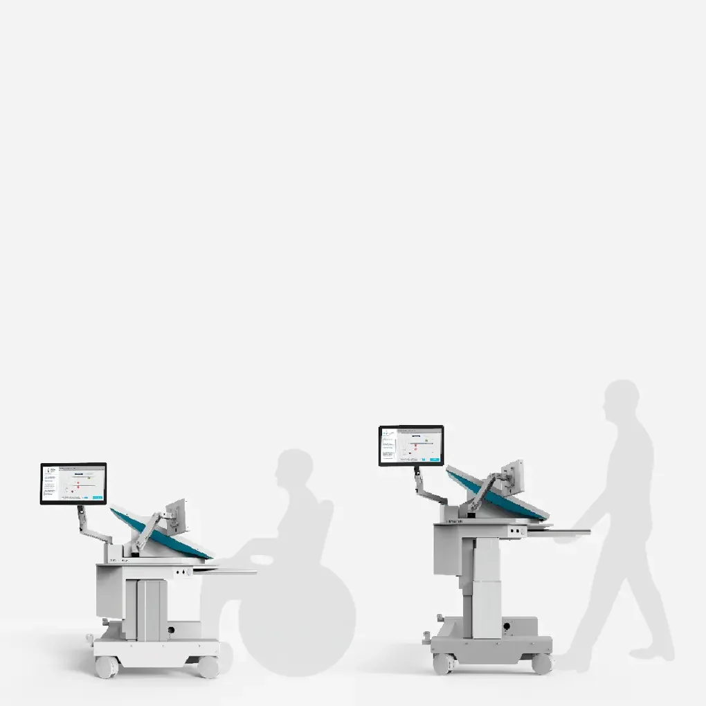 Two medical examination tables with monitors attached. One with a person in a wheelchair sitting nearby and a standing person' silhouette walking past.