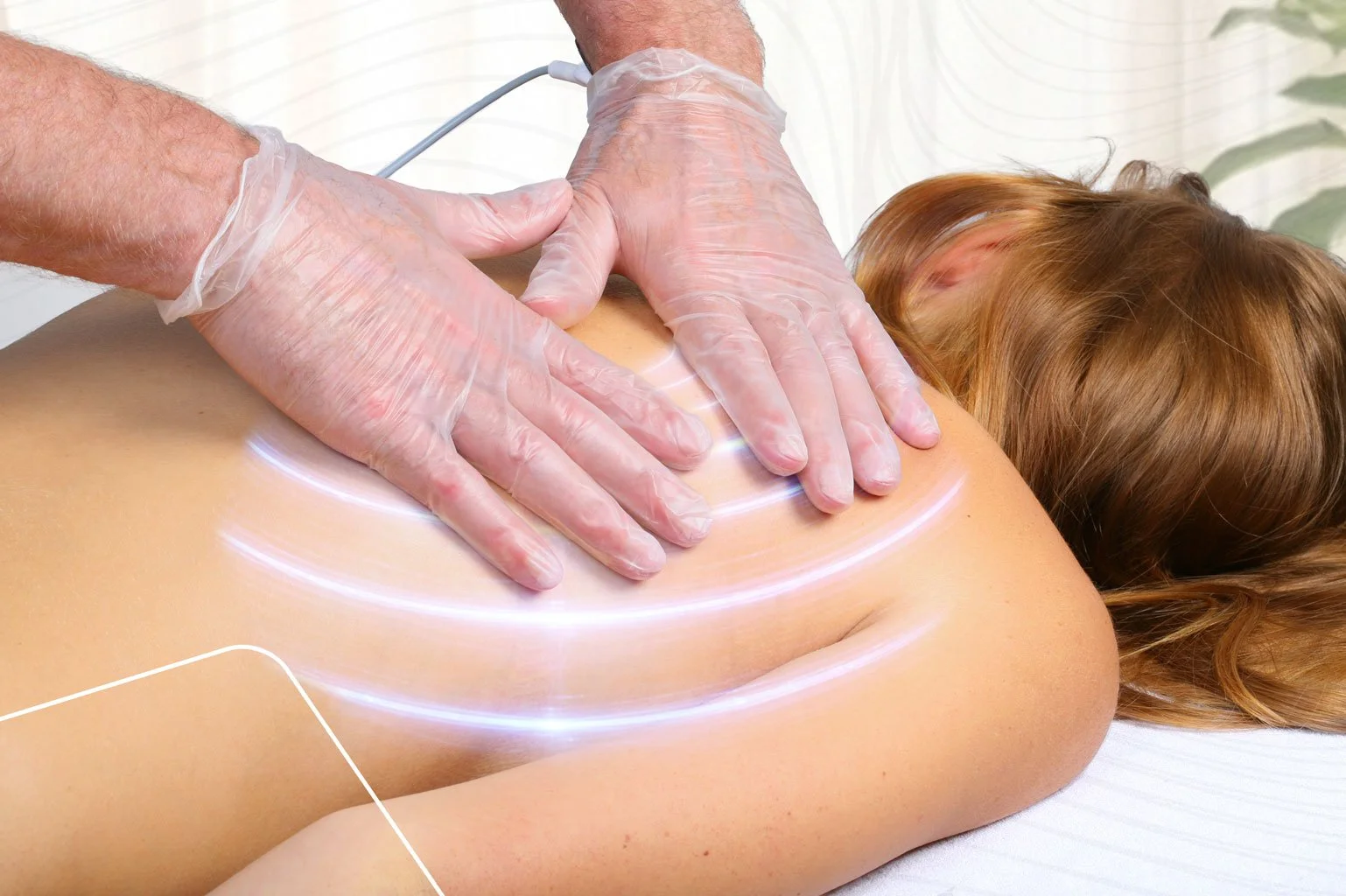 A person receiving a back massage or chiropractic treatment, with a therapist wearing gloves applying pressure on the person's back in a clinical setting.