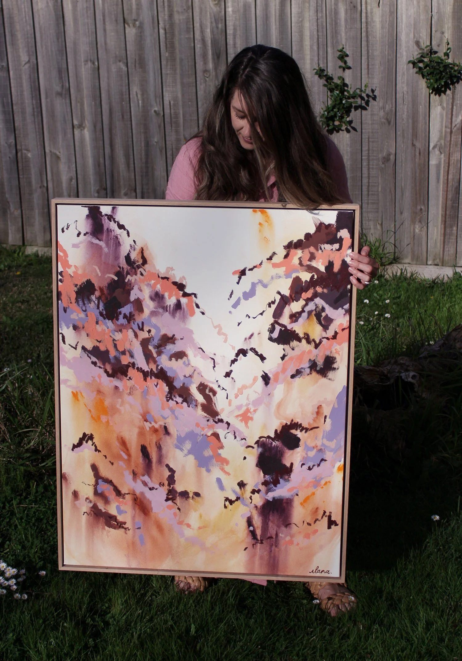 Abstract painting in coral, aubergine, dusty lavender and ochre tones forming a valley shape between two peaks, in an American ash floating frame