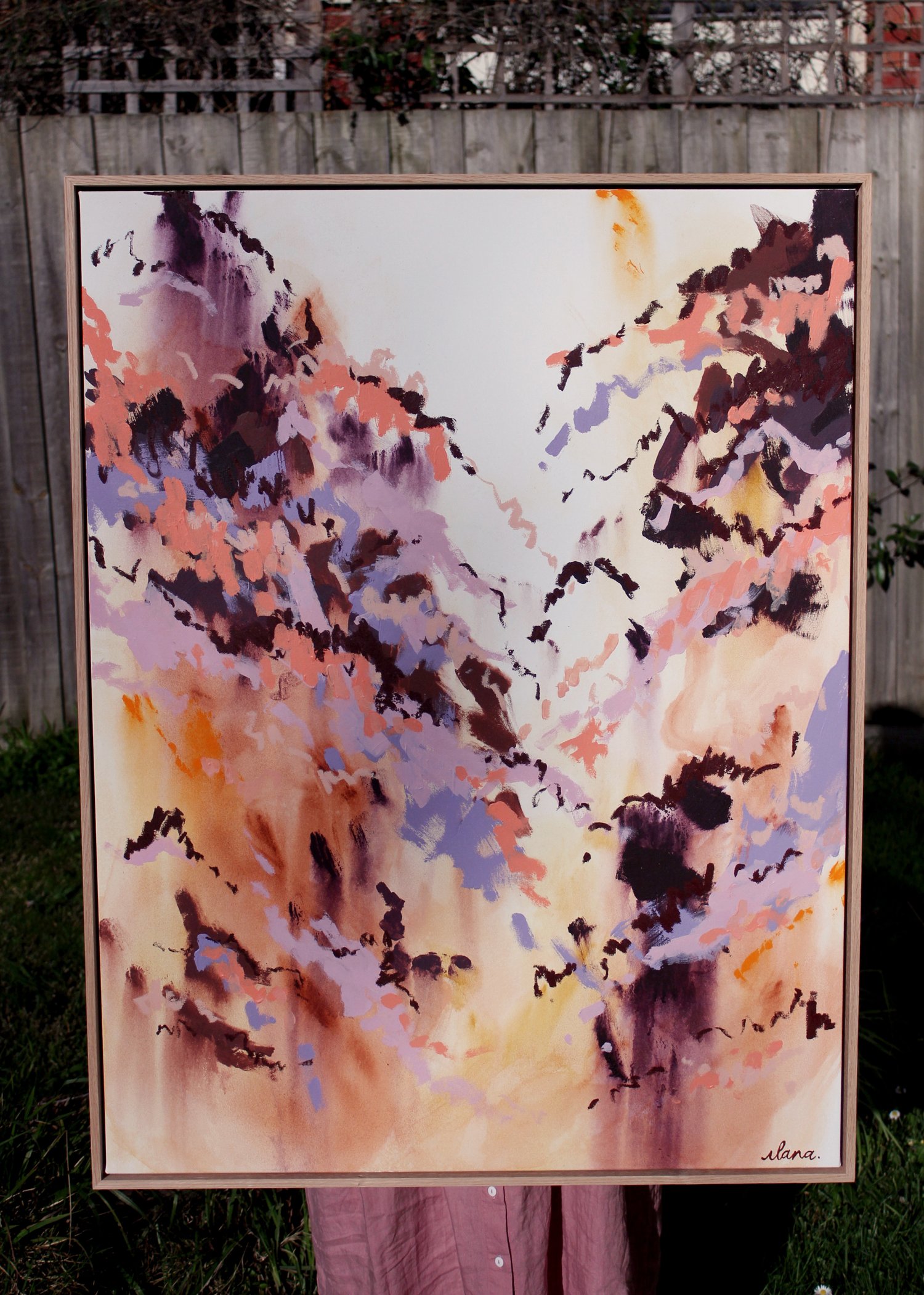 Abstract painting in coral, aubergine, dusty lavender and ochre tones forming a valley shape between two peaks, in an American ash floating frame