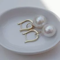 Boucles d'oreilles avec perles blanches sur une assiette blanche