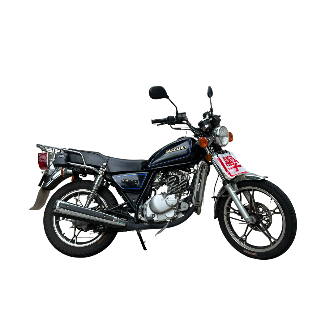 A black Suzuki GN125 motorcycle with a small windshield, sitting on a black background.