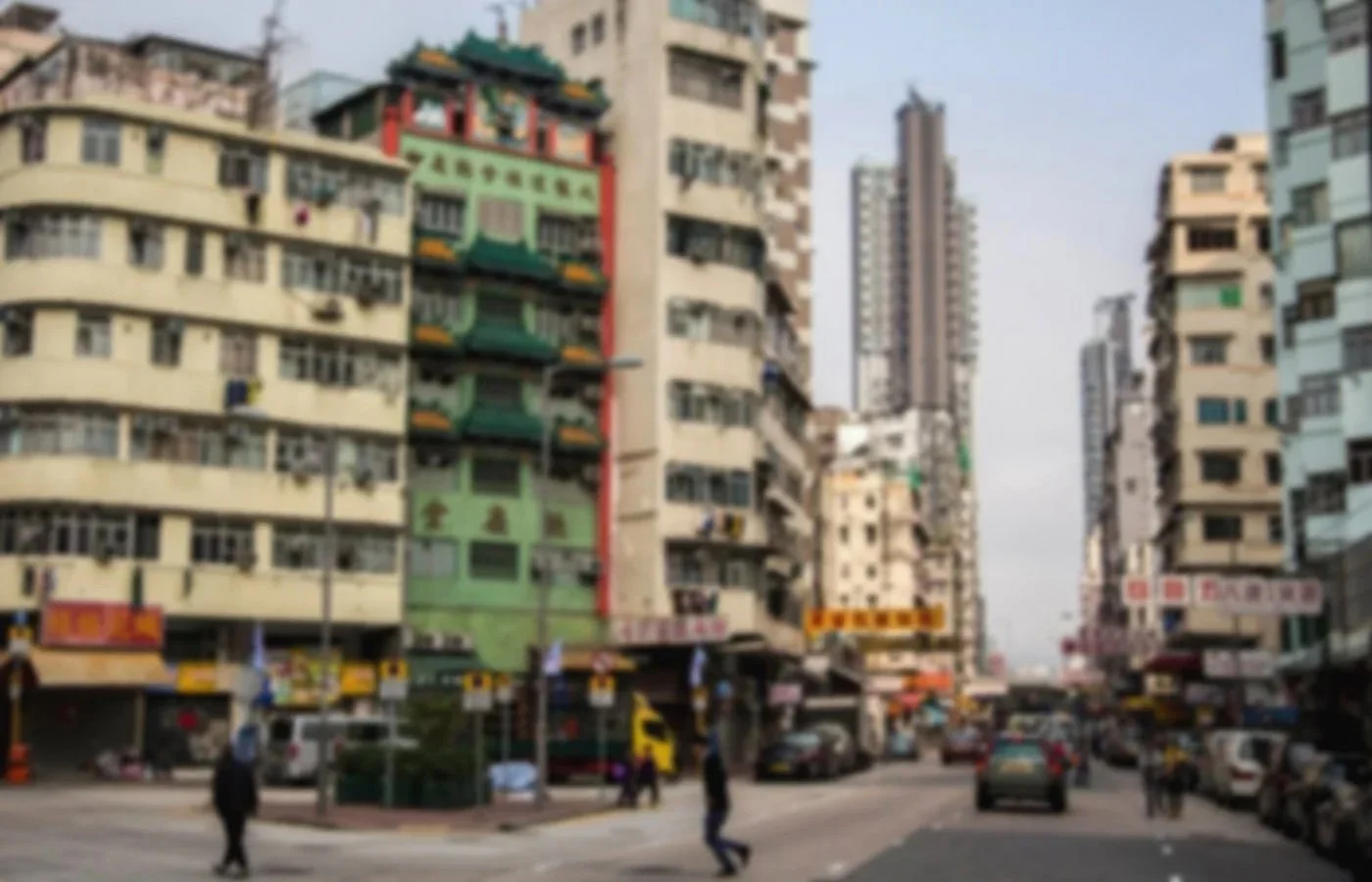 City street scene with tall buildings, cars, and pedestrians.