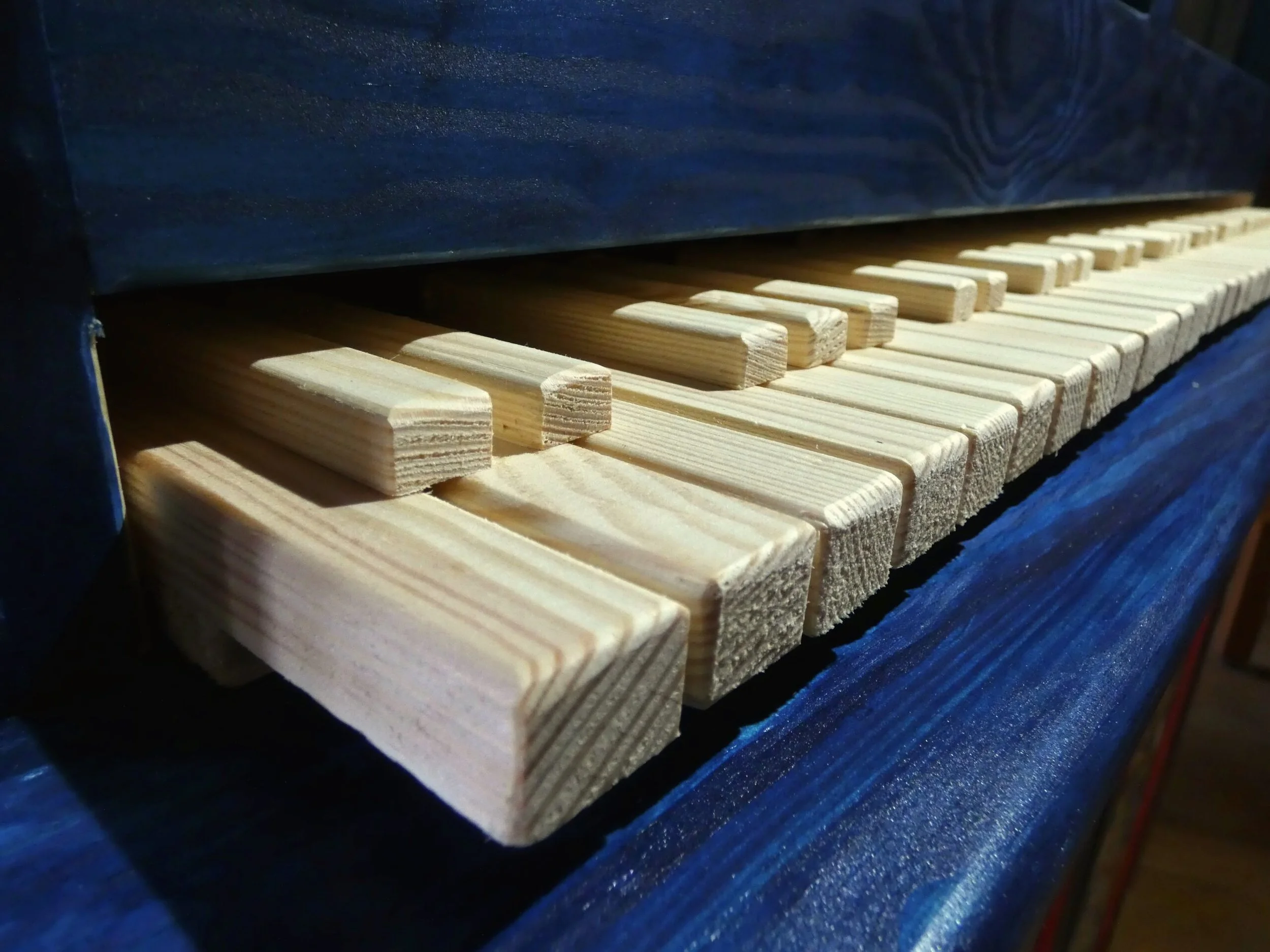 Particolare di fili di legno impilati in una macchina o una struttura, forse parte di un processo di produzione.