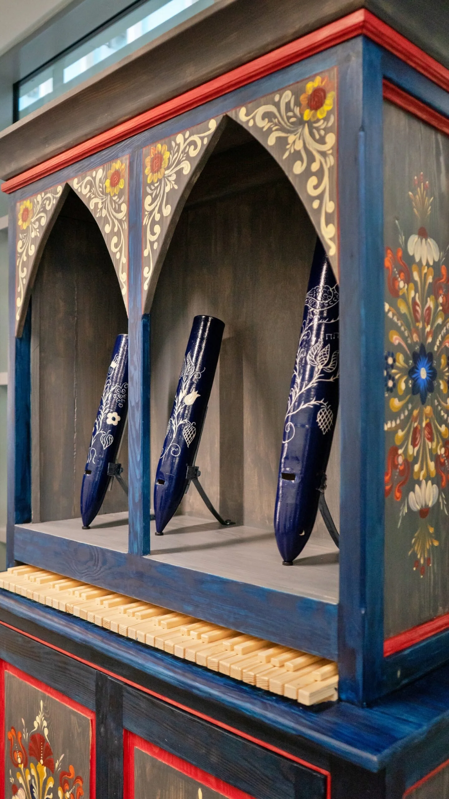 Una scatola di legno decorata con motivi floreali contiene tre tacchi di alta qualità decorati con motivi di fiori e foglie, alcuni di colore blu con dettagli bianchi e altri con motivi di fiori bianco e arancioni.