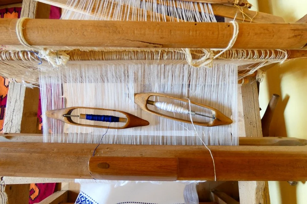 Telaio per tessitura con navette di legno, filati bianchi e blu e cellophane per modellismo