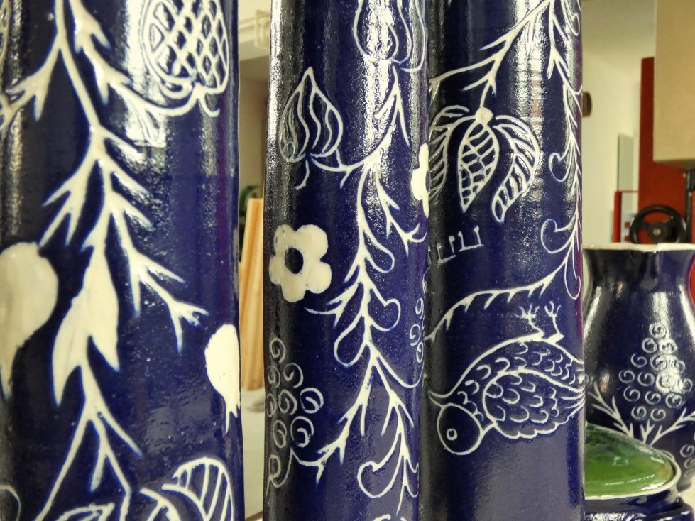 Vasi blu con motivi bianchi di fiori, foglie e pesci, positioned in un ambiente domestico.