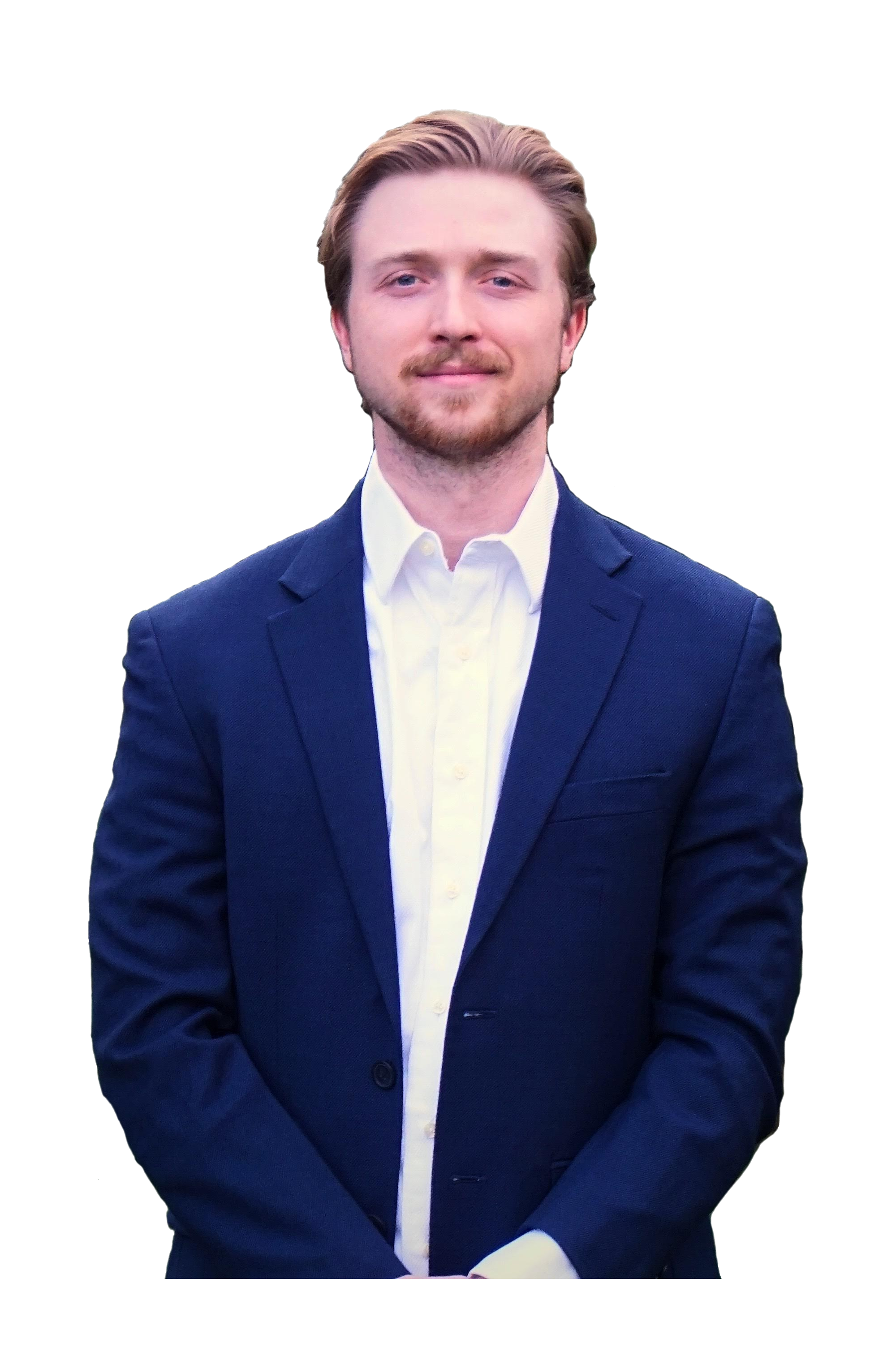A young man in a navy blue suit with a white shirt, standing and smiling against a black background.