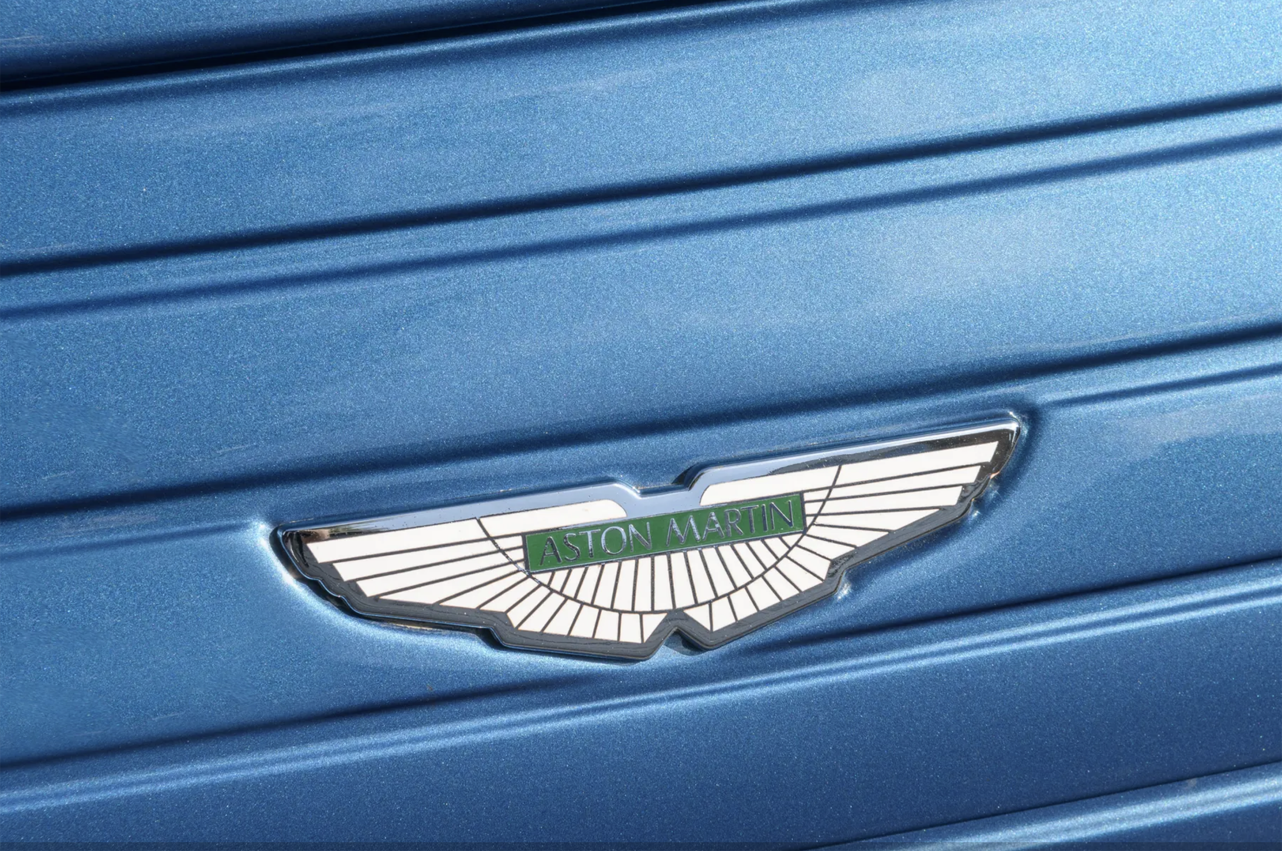 The Aston Martin wings: a marque emblem closely associated with British grand touring, hand-built craftsmanship and enduring motoring heritage.