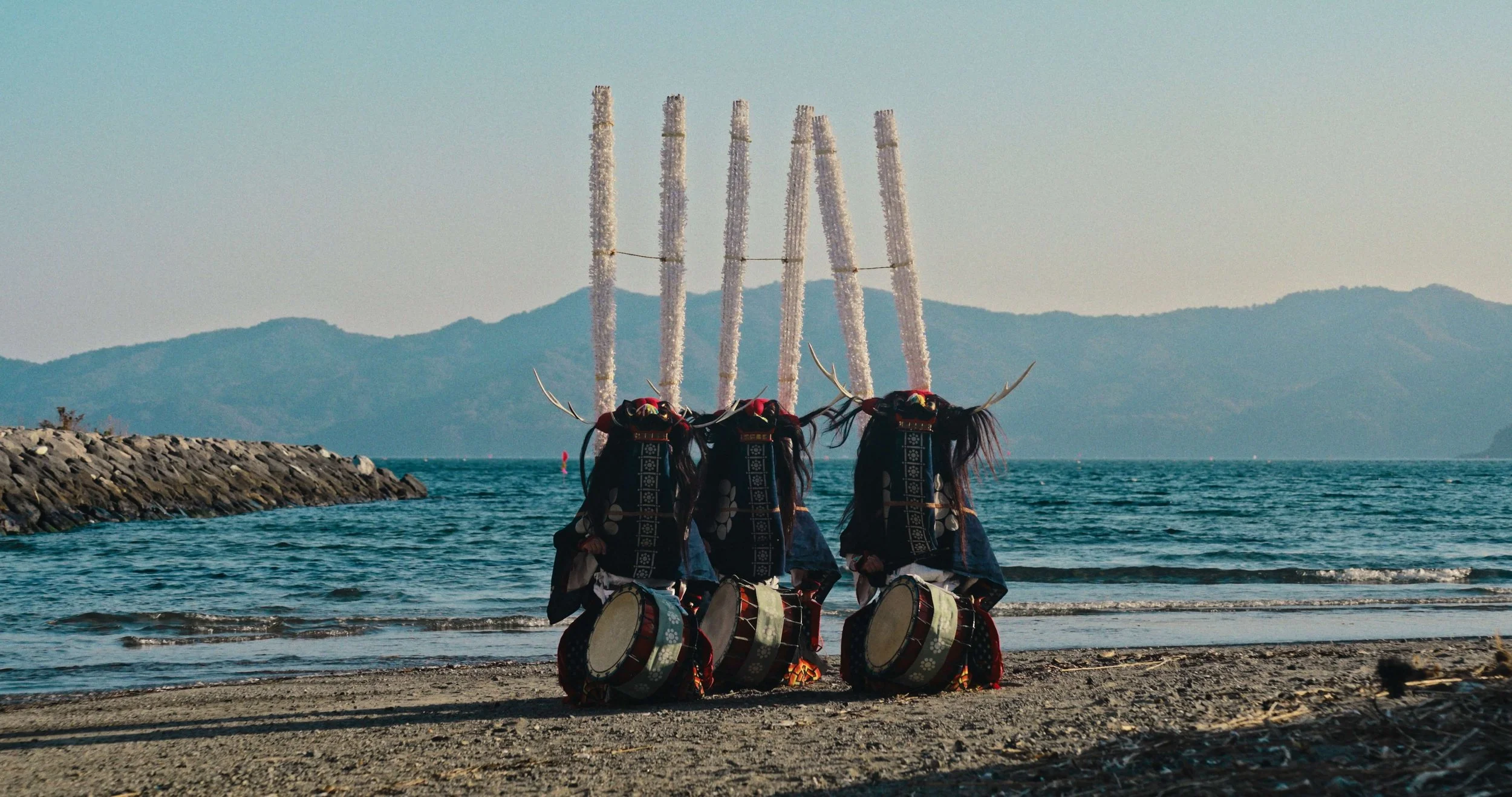 A still image from Stronger than the Wave, a documentary film by Robbie McKane, featuring three dancers in Shishi-Odori garb, a popular folk dance from the Tohoku region of Japan.
