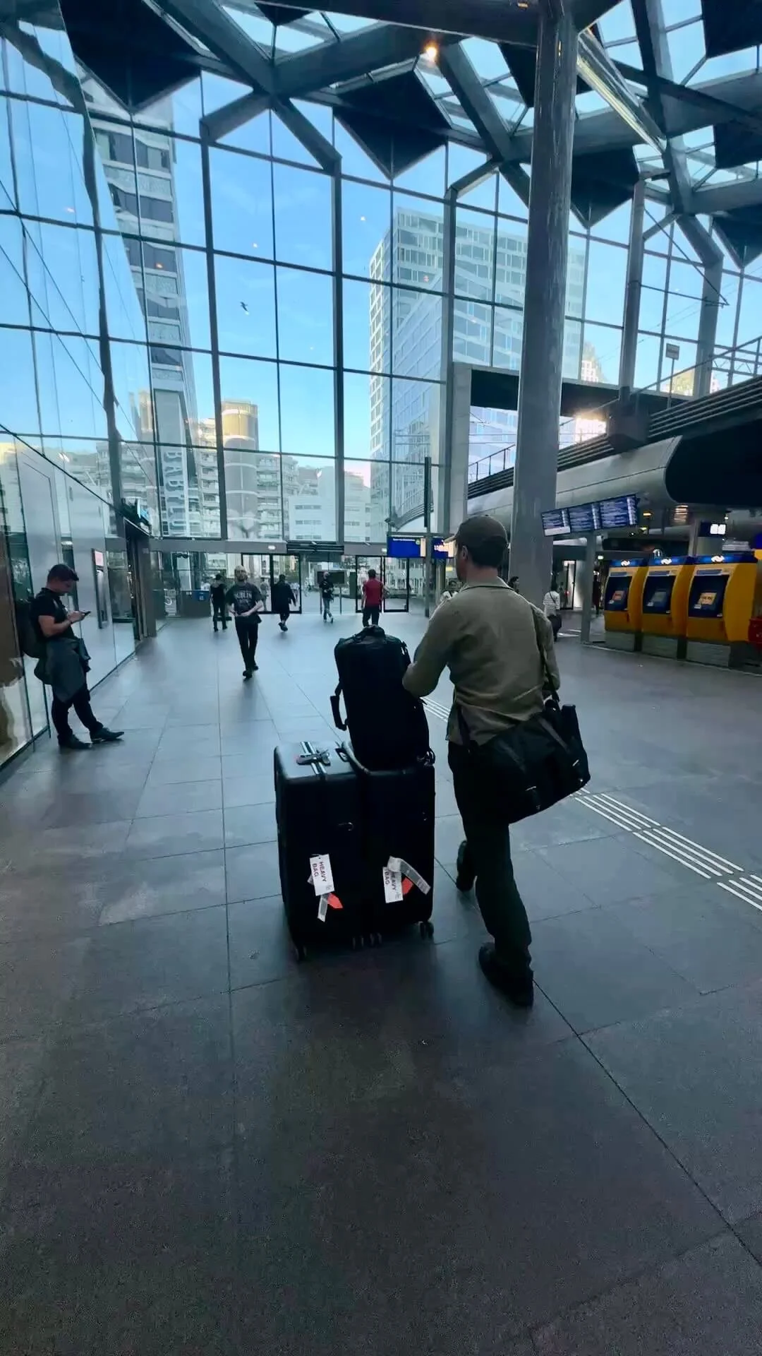 Robbie McKane rolling an equipment case through a station concourse in the Netherlands.
