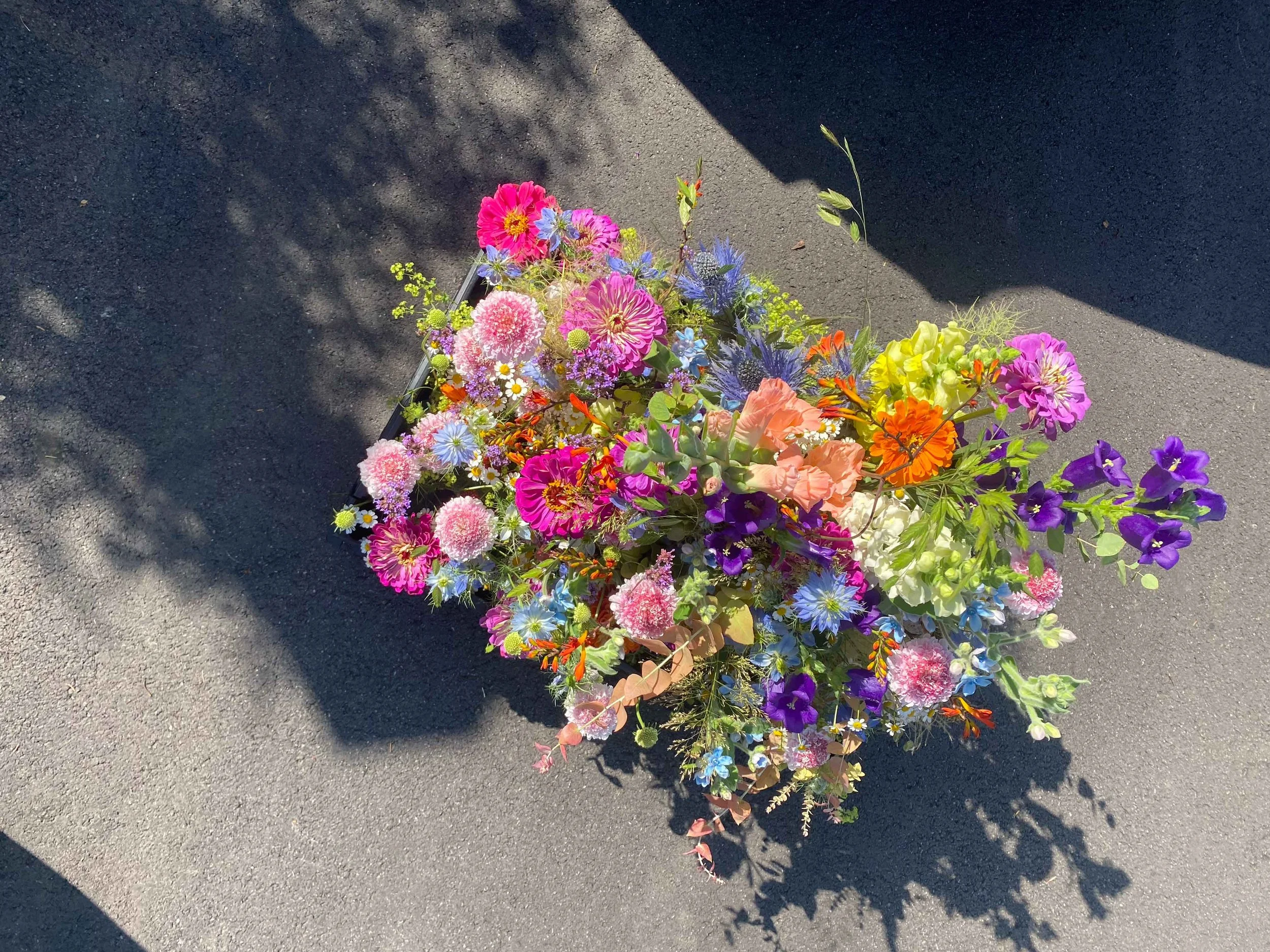 Korb mit kleinen Vasen voller wildschönes, farbigesn und sommerlichen Blumenarrangements
